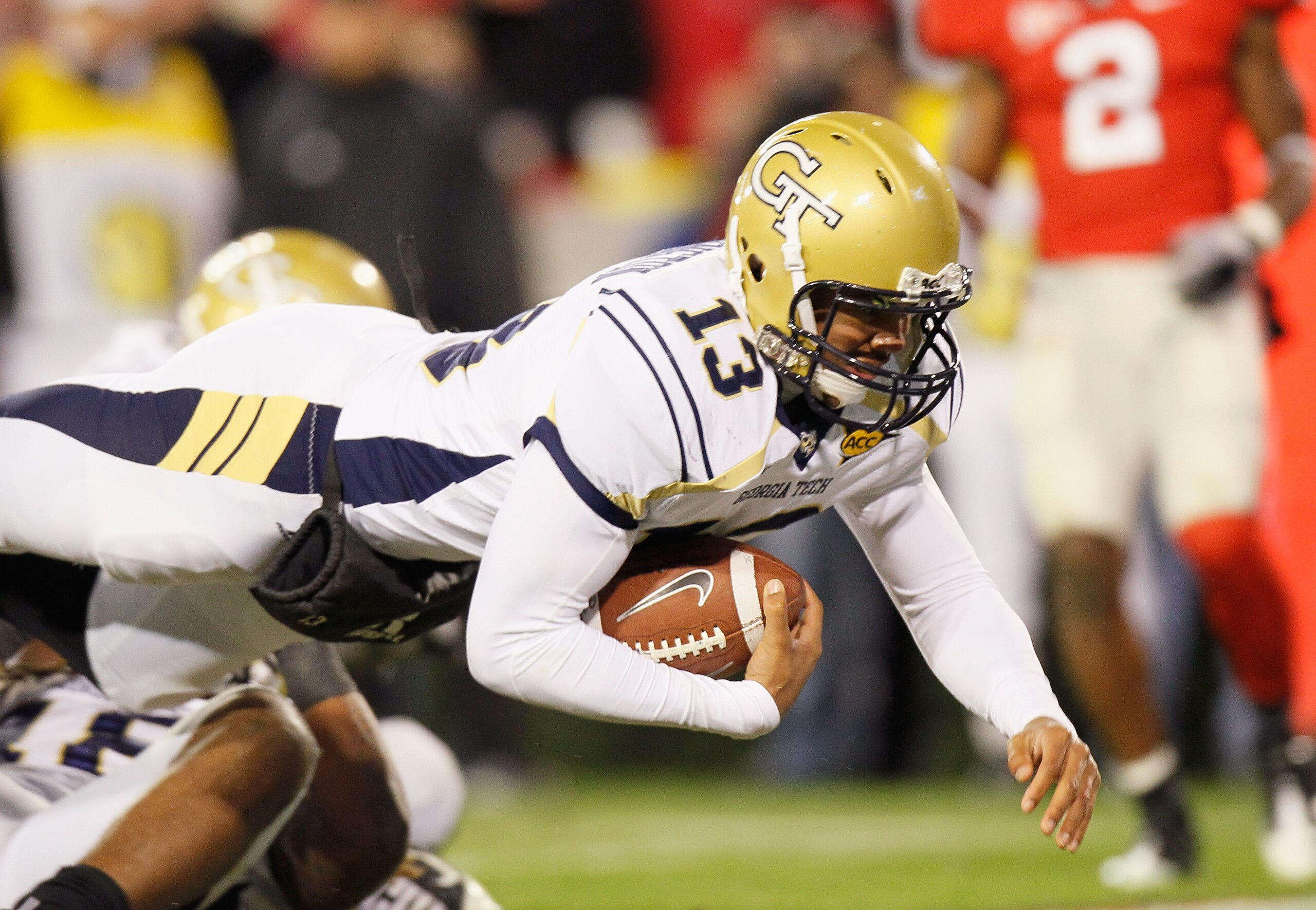 ATHENS, GA - NOVEMBER 27:  Quarterback Tevin Washington #13 of the Georgia Tech Yellow Jackets dives across the end zone for a touchdown against the Georgia Bulldogs at Sanford Stadium on November 27, 2010 in Athens, Georgia.  (Photo by Kevin C. Cox/Getty