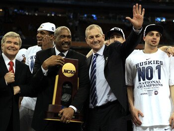 HOUSTON, TX - APRIL 04:  Athletic director Gene Smith of the Ohio State Buckeyes stands with head coach Jim Calhoun of the Connecticut Huskies as the Huskies celebrate with his team and the trophy after defeating the Butler Bulldogs to win the National Ch