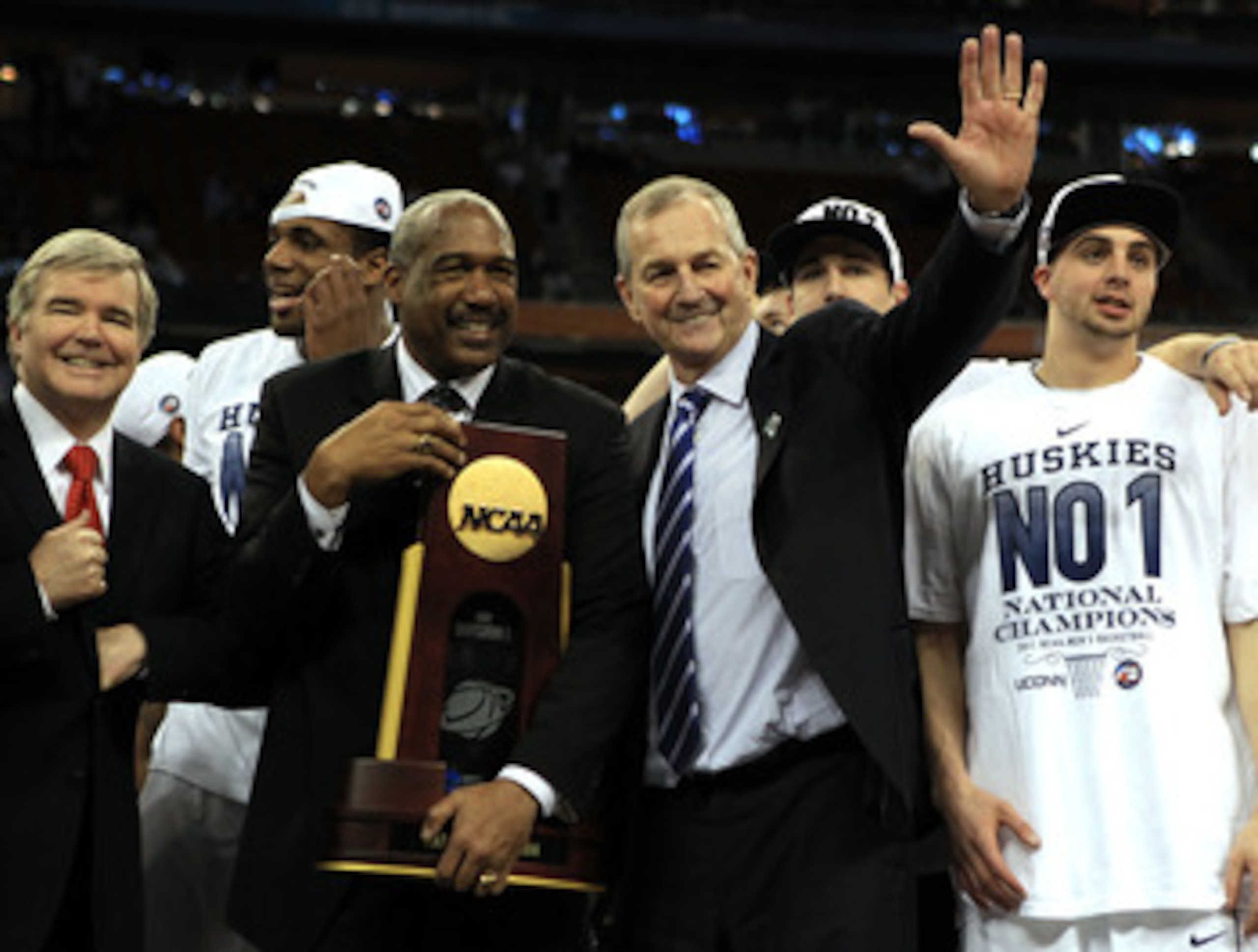 HOUSTON, TX - APRIL 04:  Athletic director Gene Smith of the Ohio State Buckeyes stands with head coach Jim Calhoun of the Connecticut Huskies as the Huskies celebrate with his team and the trophy after defeating the Butler Bulldogs to win the National Ch