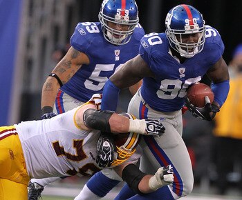 EAST RUTHERFORD, NJ - DECEMBER 05:  Jason Pierre-Paul #90 of the New York Giants runs back a fumble by the Washington Redskins during their game on December 5, 2010 at The New Meadowlands Stadium in East Rutherford, New Jersey.  (Photo by Al Bello/Getty I