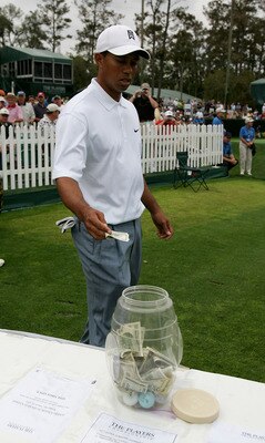 PONTE VEDRA BEACH, FL - MARCH 23: Tiger Woods thows a one hundred dollar bill into the charity pot on the 17th tee during practice prior to The Players Championship at the TPC at Sawgrass on March 23, 2005 in Ponte Vedra Beach, Florida. (Photo by Richar PONTE VEDRA BEACH, FL - MARCH 23: Tiger Woods thows a one hundred dollar bill into the charity pot on the 17th tee during practice prior to The Players Championship at the TPC at Sawgrass on March 23, 2005 in Ponte Vedra Beach, Florida. (Photo by Richar