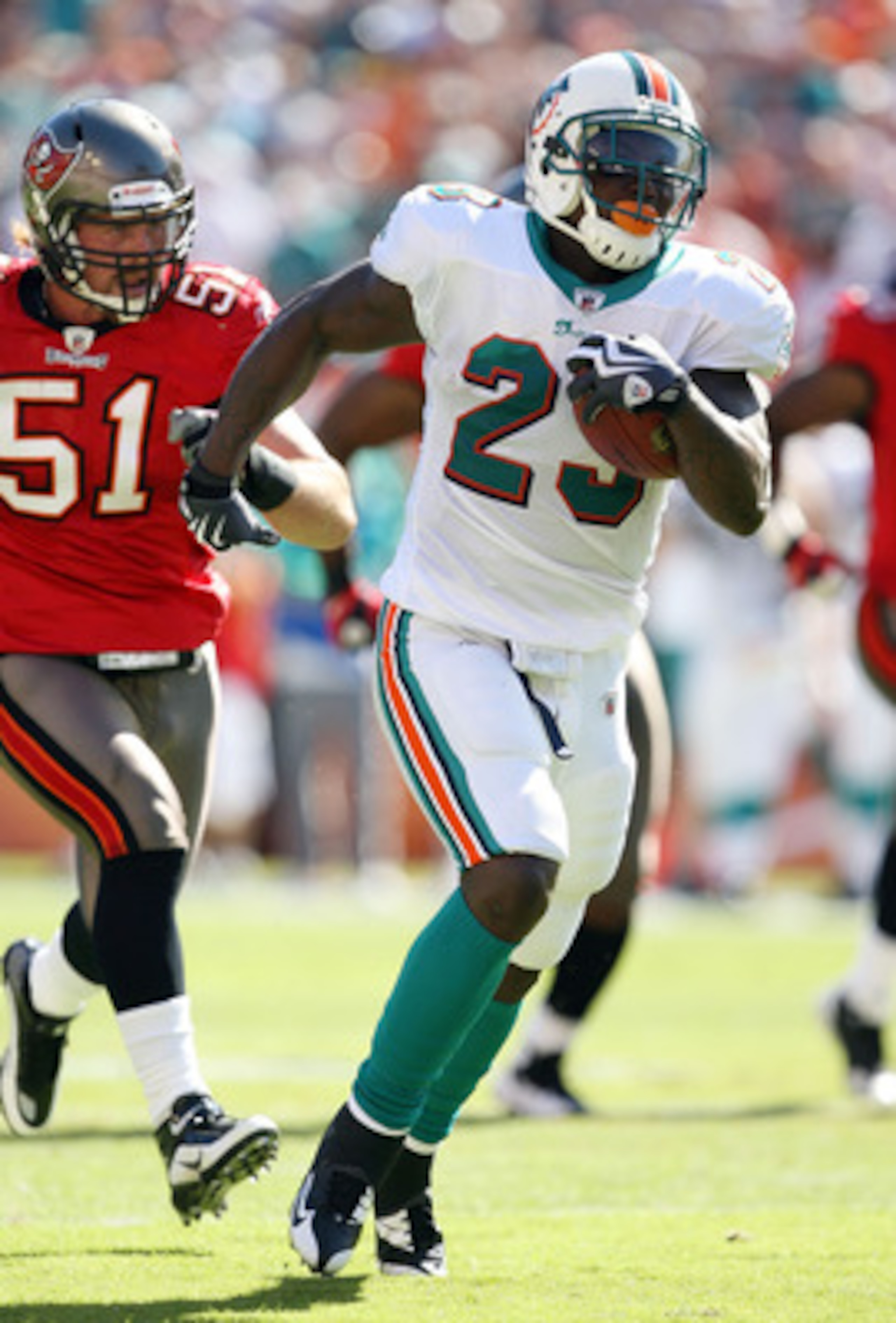 MIAMI GARDENS, FL - NOVEMBER 15:  Running back Ronnie Brown #23 of the Miami Dolphins runs past linebacker Barrett Ruud #51 of the Tampa Bay Buccaneers at Land Shark Stadium on November 15, 2009 in Miami Gardens, Florida.  (Photo by Doug Benc/Getty Images