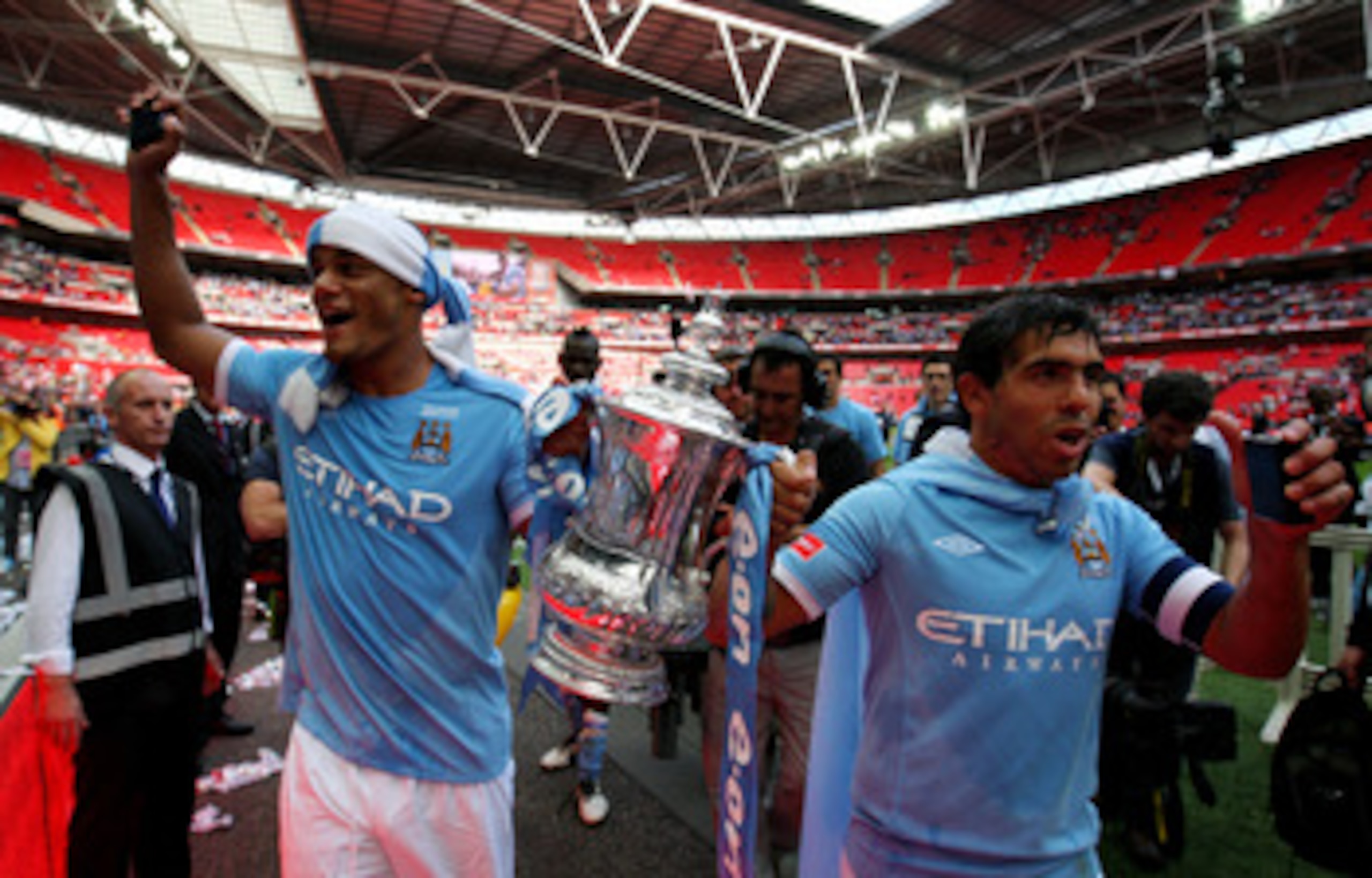 LONDON, ENGLAND - MAY 14:  Vincent Kompany (L) and Carlos Tevez of Manchester City celebrate with the trophy following the FA Cup sponsored by E.ON Final match between Manchester City and Stoke City at Wembley Stadium on May 14, 2011 in London, England.  