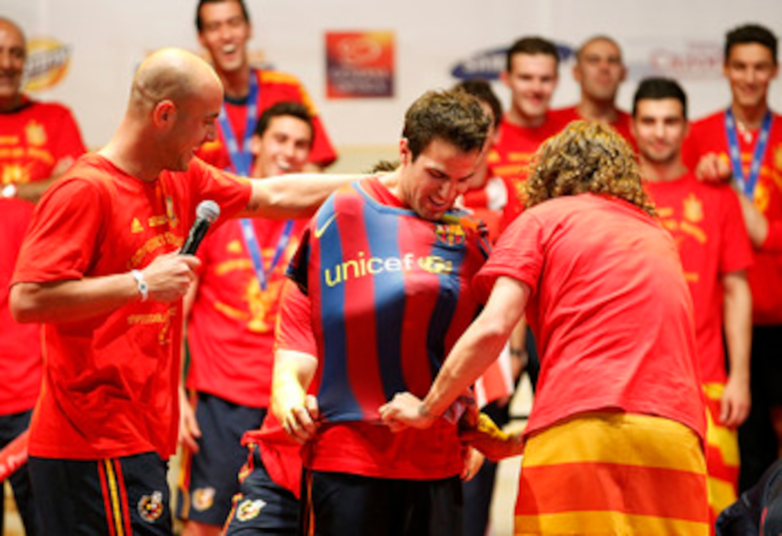 MADRID, SPAIN - JULY 12:  Pepe Reina (L) Gerard Pique (hidden) and Carles Puyol of the Spanish national football team put a FC Barcelona shirt on team mate Cesc Fabregas during the Spanish team's victory parade following their victory over the Netherlands