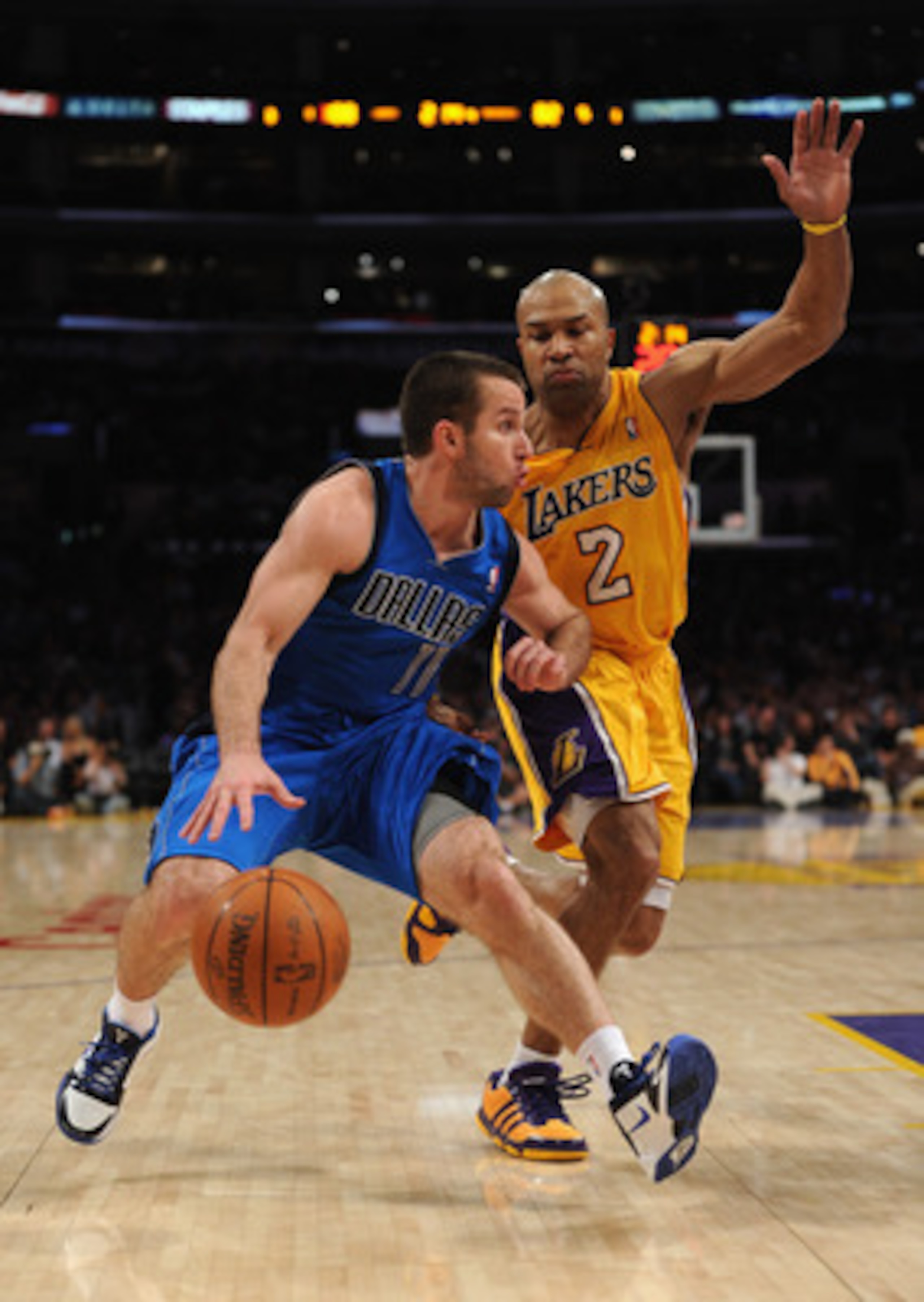 LOS ANGELES, CA - MARCH 31:  Jose Barea #11 of the Dallas Mavericks dribbles past Derek Fisher #2 of the Los Angeles Lakers at Staples Center on March 31, 2011 in Los Angeles, California.  NOTE TO USER: User expressly acknowledges and agrees that, by down