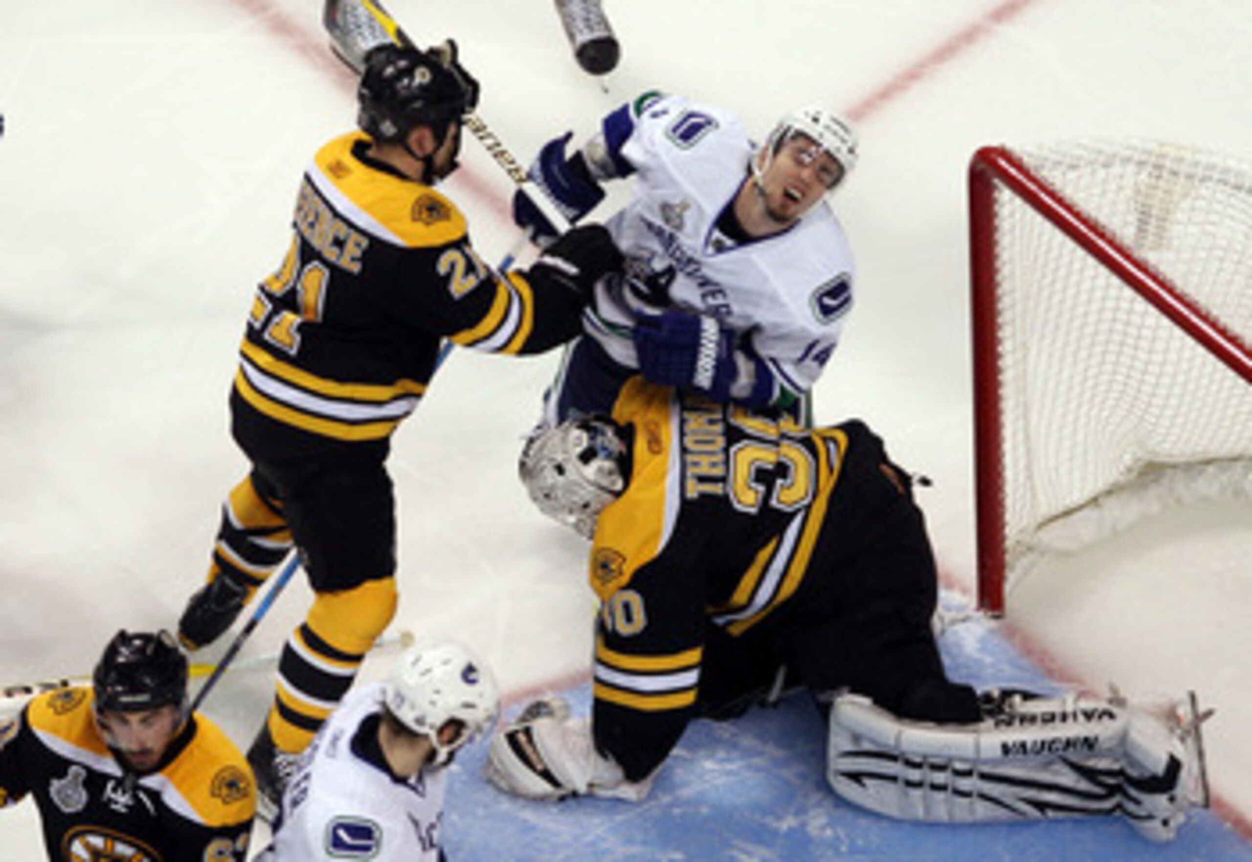 BOSTON, MA - JUNE 13: Andrew Ference #21 of the Boston Bruins checks Alex Burrows #14 of the Vancouver Canucks over the back of Tim Thomas #30 during Game Six of the 2011 NHL Stanley Cup Final at TD Garden on June 13, 2011 in Boston, Massachusetts. (Pho BOSTON, MA - JUNE 13: Andrew Ference #21 of the Boston Bruins checks Alex Burrows #14 of the Vancouver Canucks over the back of Tim Thomas #30 during Game Six of the 2011 NHL Stanley Cup Final at TD Garden on June 13, 2011 in Boston, Massachusetts. (Pho