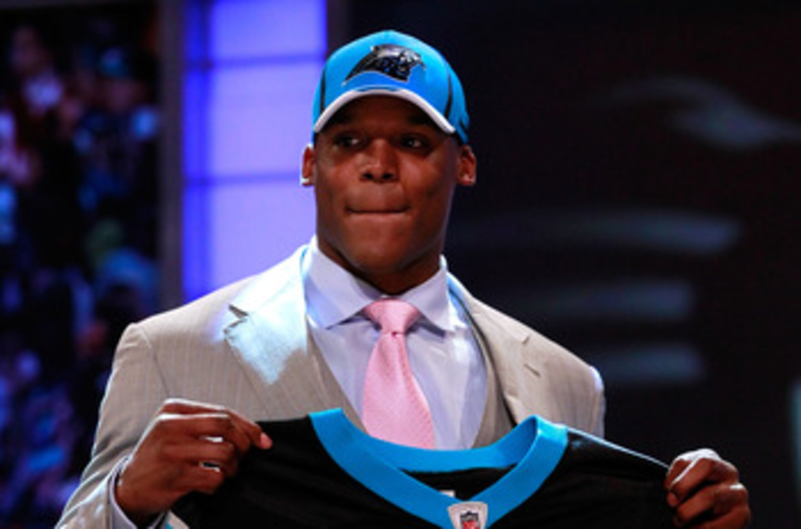 NEW YORK, NY - APRIL 28:  Cam Newton, #1 overall pick by the Carolina Panthers holds up a jersey on stage after he was picked during the 2011 NFL Draft at Radio City Music Hall on April 28, 2011 in New York City.  (Photo by Chris Trotman/Getty Images)