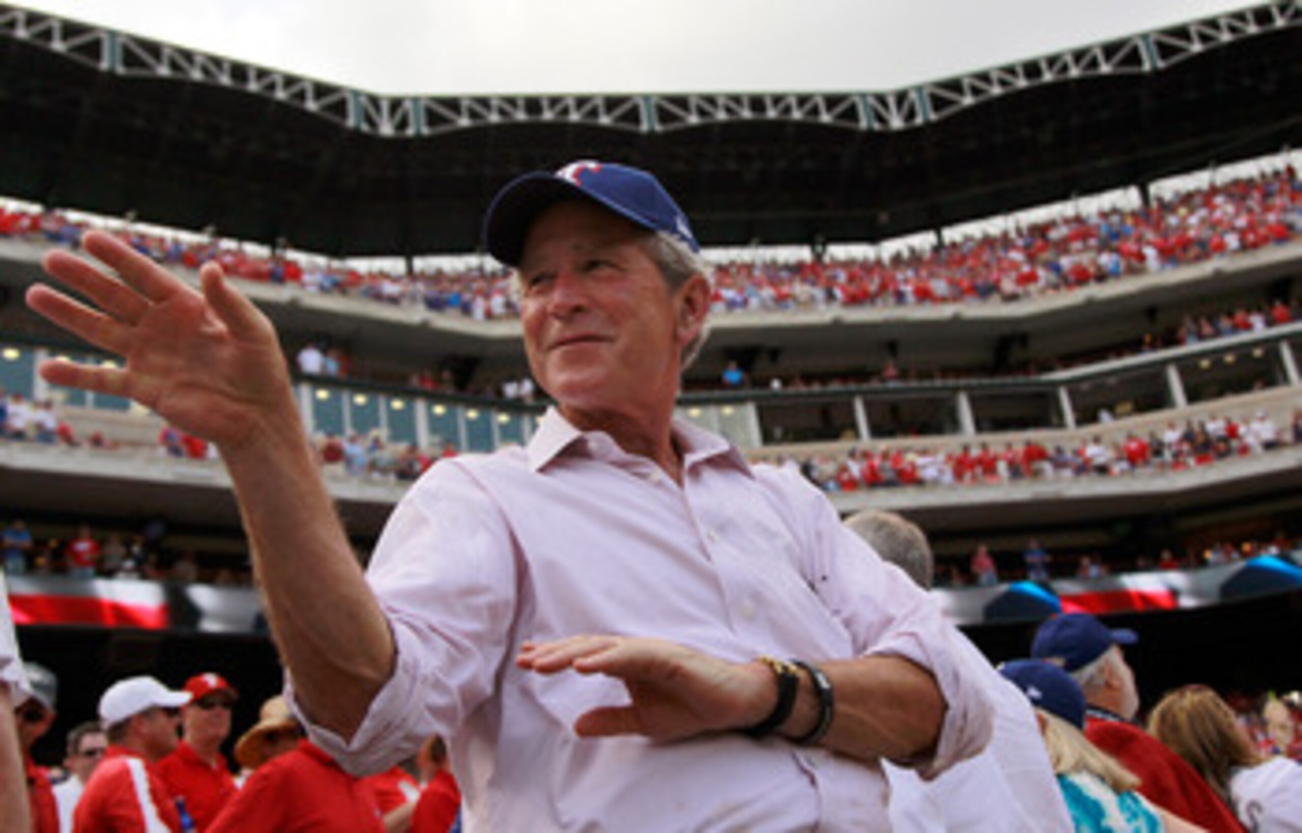ARLINGTON, TX - APRIL 01:  Former U.S. President George W. Bush waves to a fan on Opening Day at Rangers Ballpark in Arlington on April 1, 2011 in Arlington, Texas.  (Photo by Tom Pennington/Getty Images)