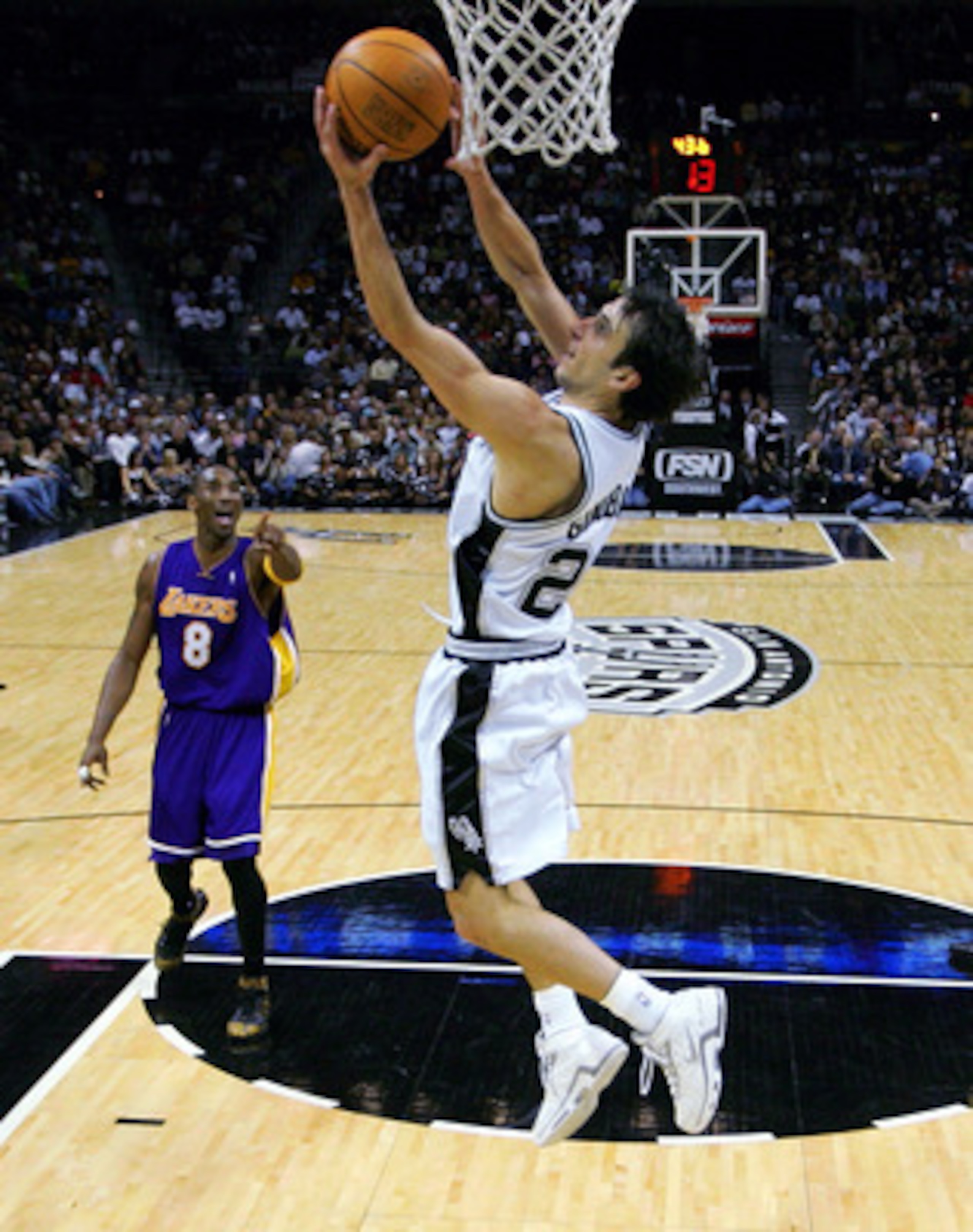 SAN ANTONIO - NOVEMBER 29:  Guard Manu Ginobili #20 of the San Antonio Spurs makes a reverse basket against Kobe Bryant #8 of the Los Angeles Lakers on November 29, 2005 at the SBC Center in San Antonio, Texas.  NOTE TO USER: User expressly acknowledges a