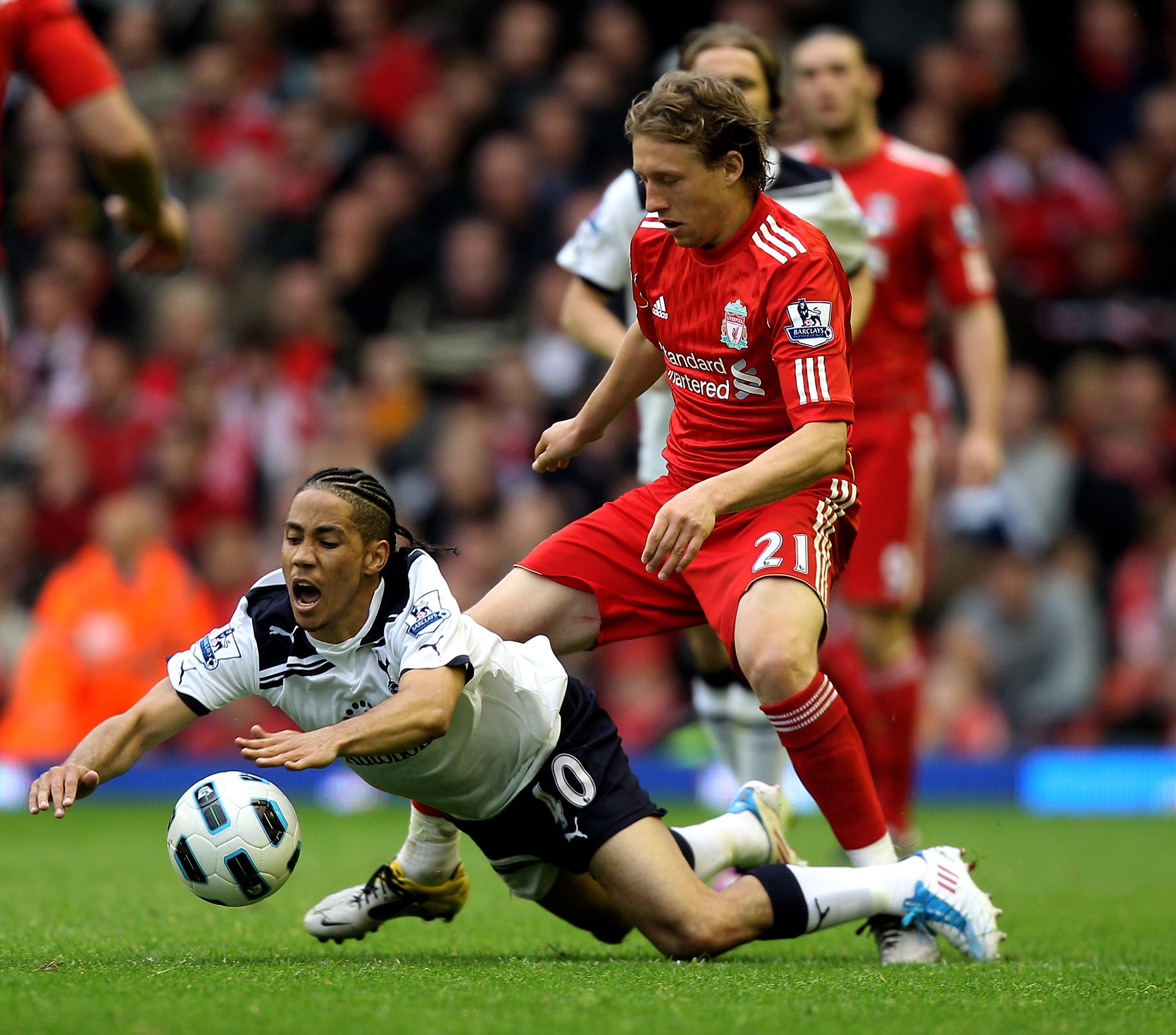LIVERPOOL, ENGLAND - MAY 15:  Steven Pienaar of Spurs is brought down by Lucas of Liverpool during the Barclays Premier League match between Liverpool and Tottenham Hotspur at Anfield on May 15, 2011 in Liverpool, England.  (Photo by Michael Steele/Getty