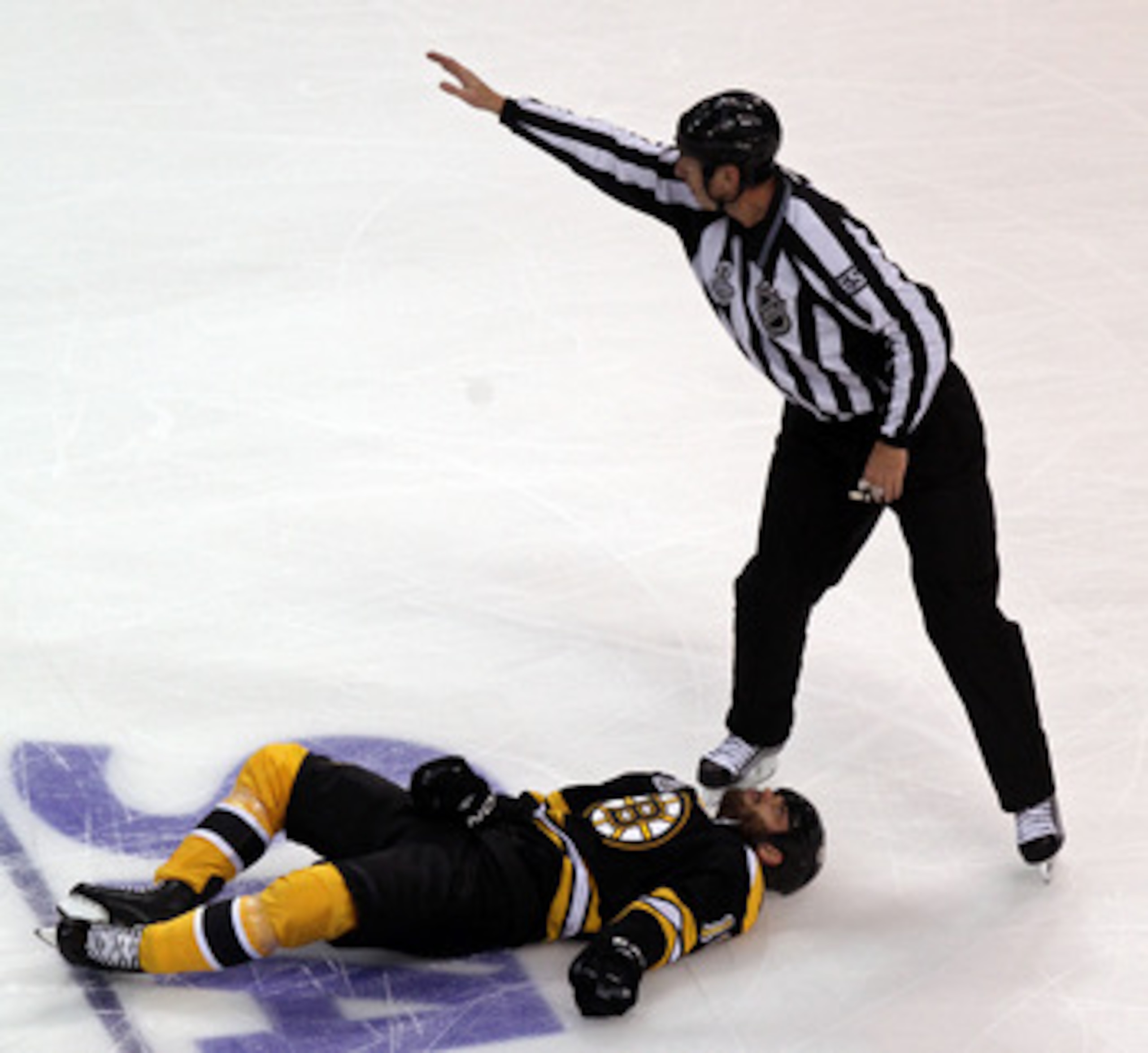 BOSTON, MA - JUNE 06:  Linesman Pierre Racicot #65 calls for assistance for Nathan Horton #18 of the Boston Bruins after being check by Aaron Rome (not pictured) #29 of the Vancouver Canucks during Game Three of the 2011 NHL Stanley Cup Final at TD Garden