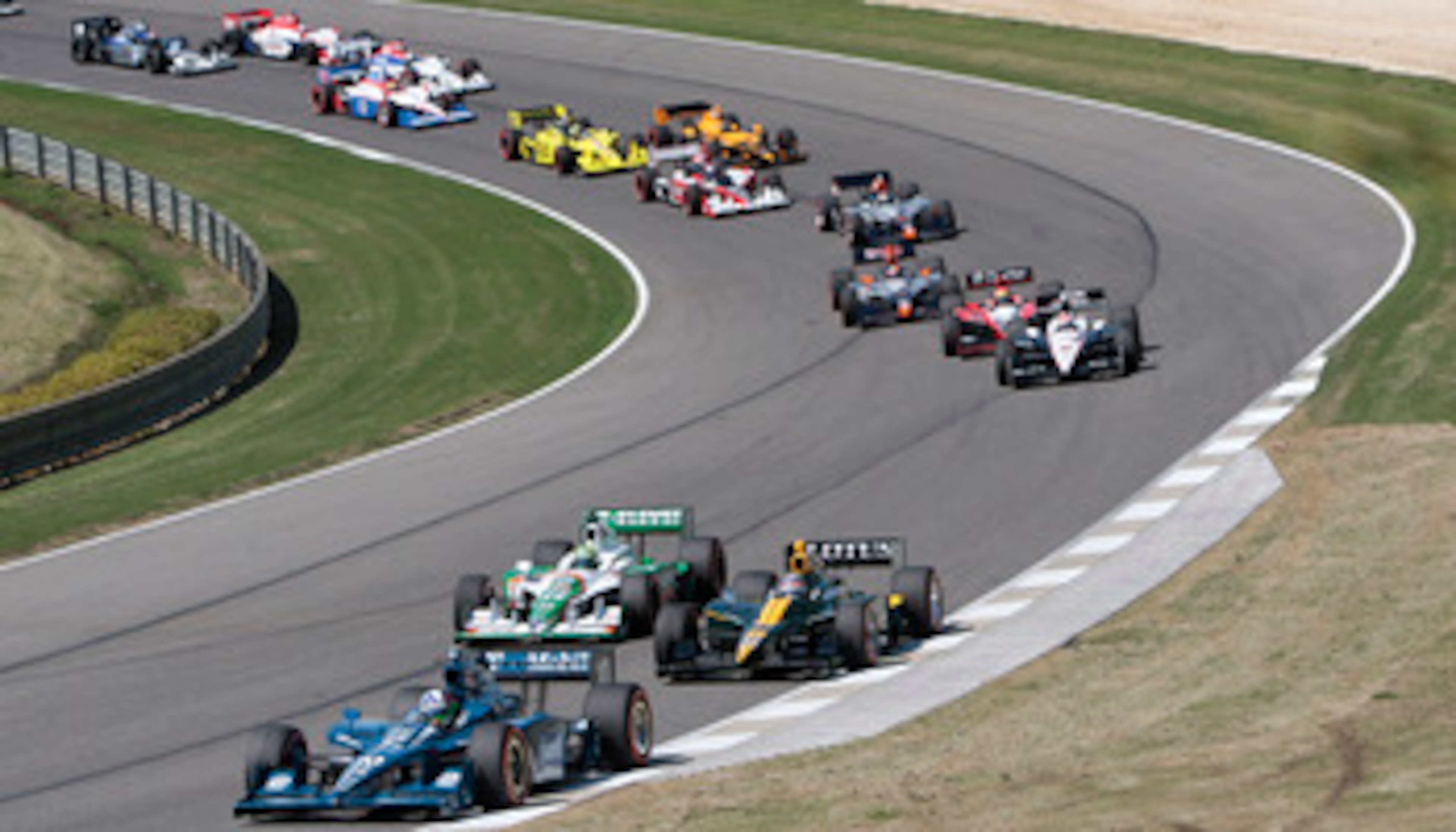 LEEDS, AL - APRIL 11: Dario Franchitti of Scotland, driver of the #10 Cottonelle Target Chip Ganassi Racing Dallara Honda leads a pack of cars through turn two at the start of the Indy Grand Prix of Alabama at the Barber Motorsports Park on April 11, 2010