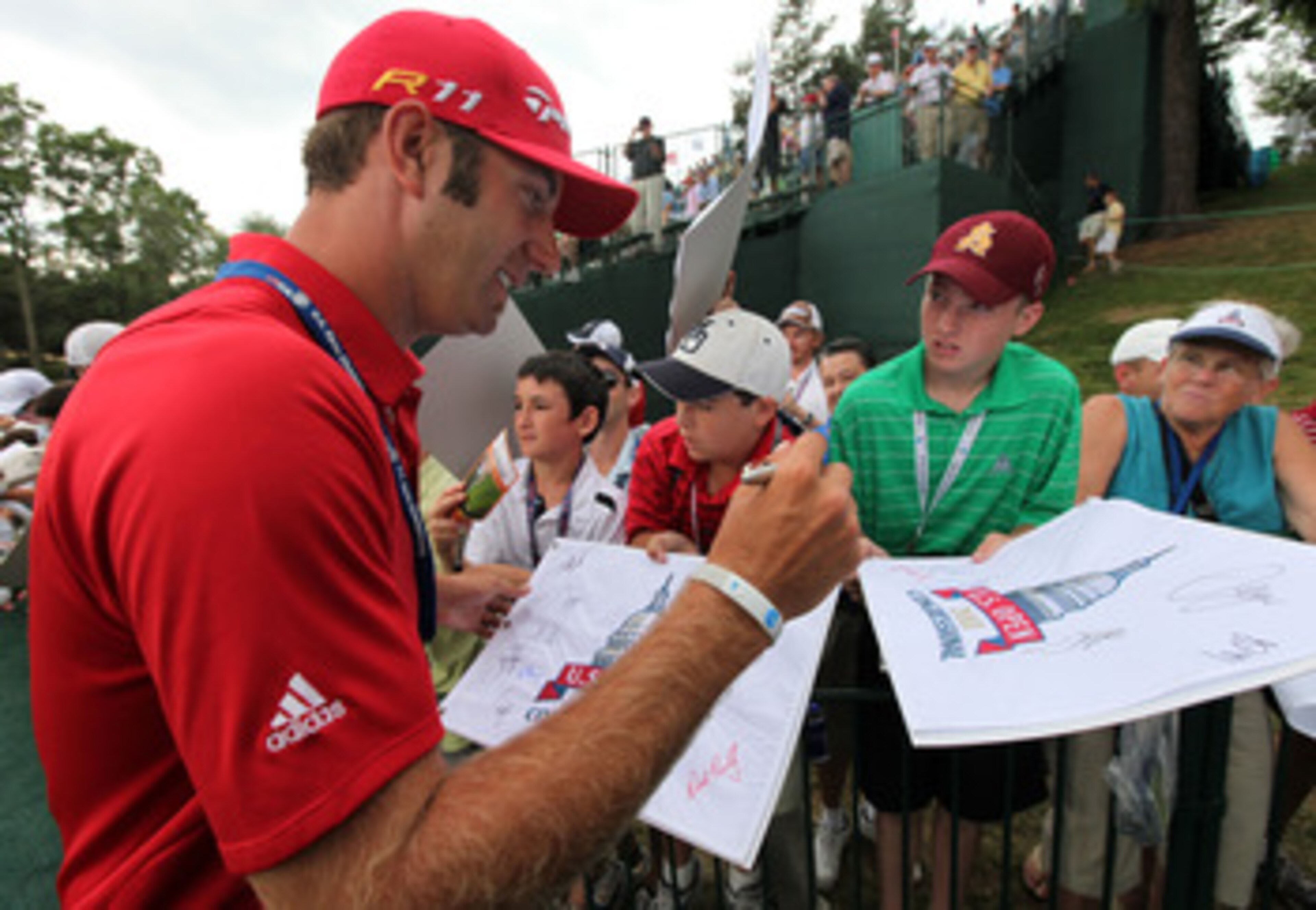 BETHESDA, MD - JUNE 14:  Dustin Johnson signs his autograph for fans during a practice round prior to the start of the 111th U.S. Open at Congressional Country Club on June 14, 2011 in Bethesda, Maryland.  (Photo by Rob Carr/Getty Images)