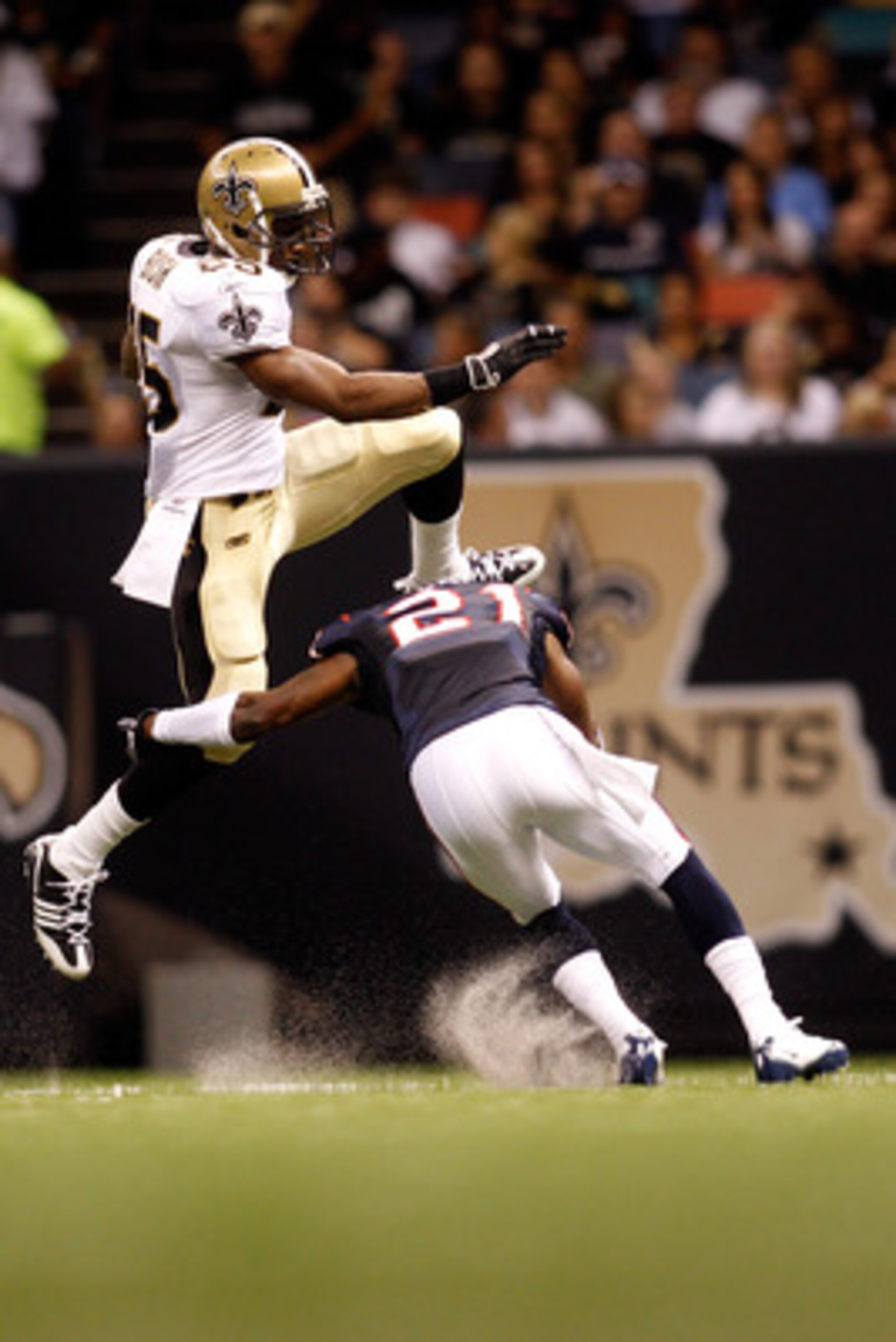 NEW ORLEANS - AUGUST 21:  Reggie Bush #25 of the New Orleans Saints jumps over Brice McCain #21 of the Houston Texans at the Louisiana Superdome on August 21, 2010 in New Orleans, Louisiana.  (Photo by Chris Graythen/Getty Images)