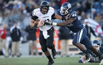 EAST HARTFORD, CT - NOVEMBER 27:  Zach Collaros #12 of the Cincinnati Bearcats carries the ball as Sio Moore #46 of the Connecticut Huskies makes the tackle on November 27, 2010 at Rentschler Field in East Hartford, Connecticut. The Huskies defeated the B