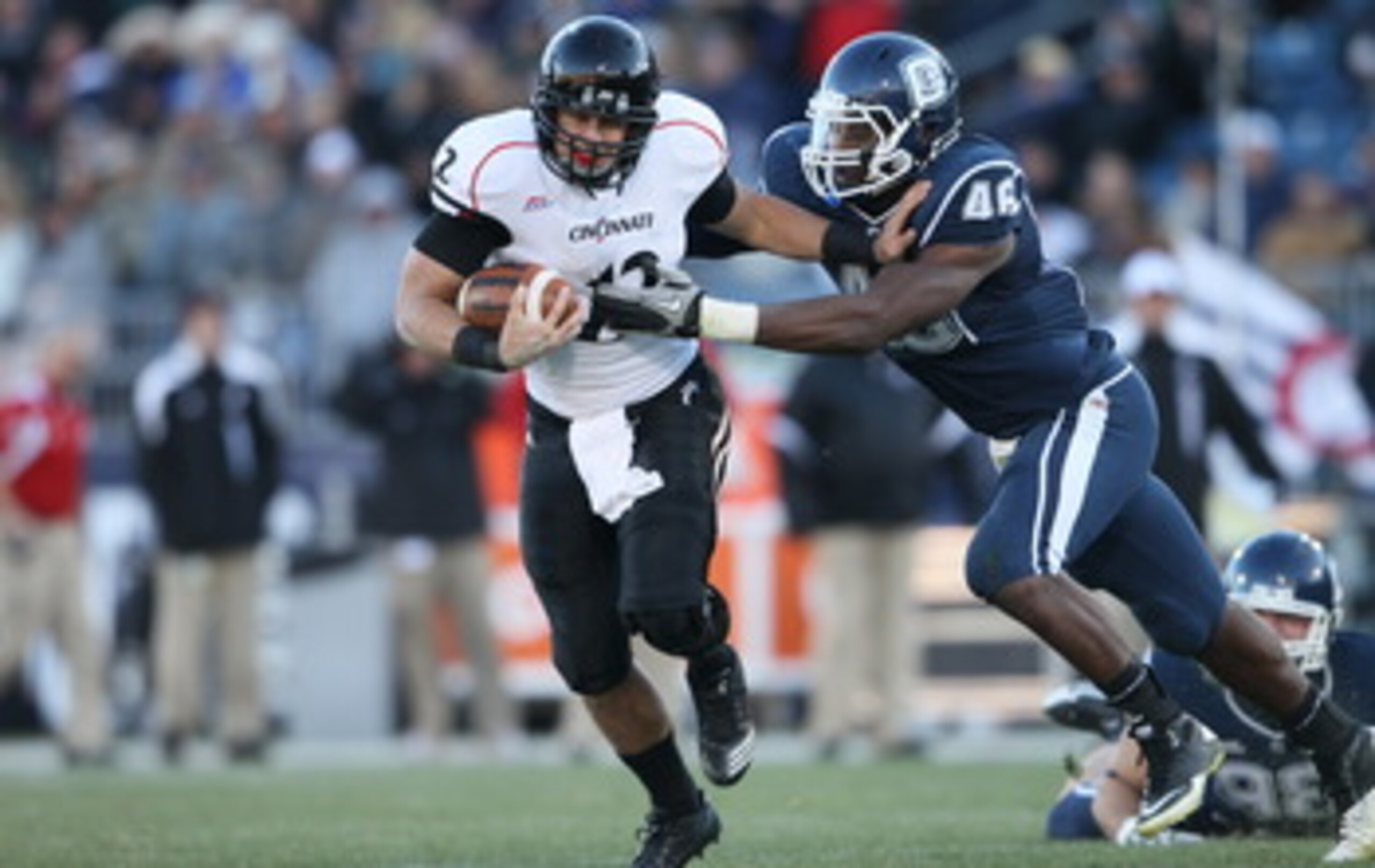 EAST HARTFORD, CT - NOVEMBER 27:  Zach Collaros #12 of the Cincinnati Bearcats carries the ball as Sio Moore #46 of the Connecticut Huskies makes the tackle on November 27, 2010 at Rentschler Field in East Hartford, Connecticut. The Huskies defeated the B