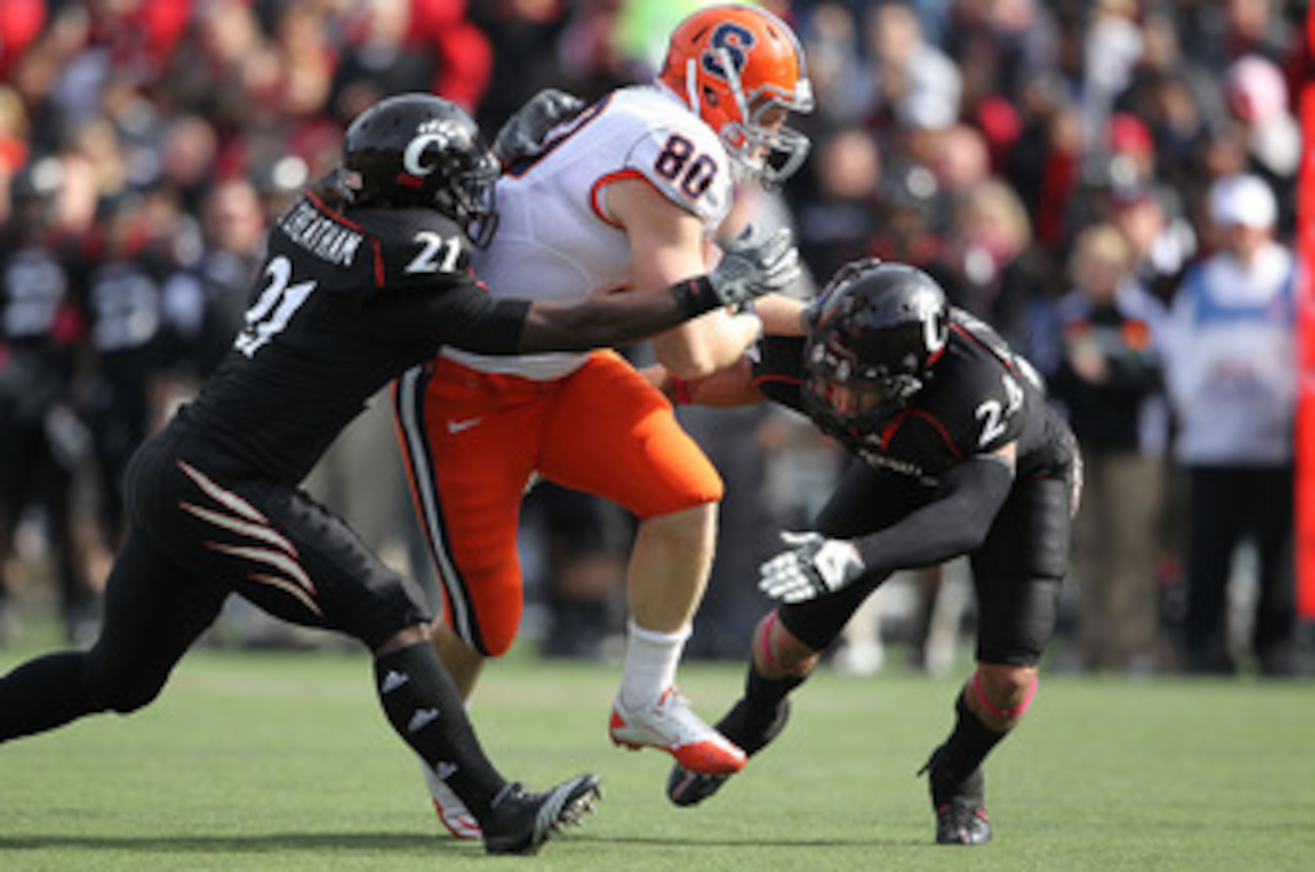 CINCINNATI - OCTOBER 30:  Nick Provo #80 of the Syracuse Orange runs with the ball while defended by Camerron Cheatham #21 and Wesley Richardson #24 of the Cincinnati Bearcats at Nippert Stadium on October 30, 2010 in Cincinnati, Ohio.  (Photo by Andy Lyo