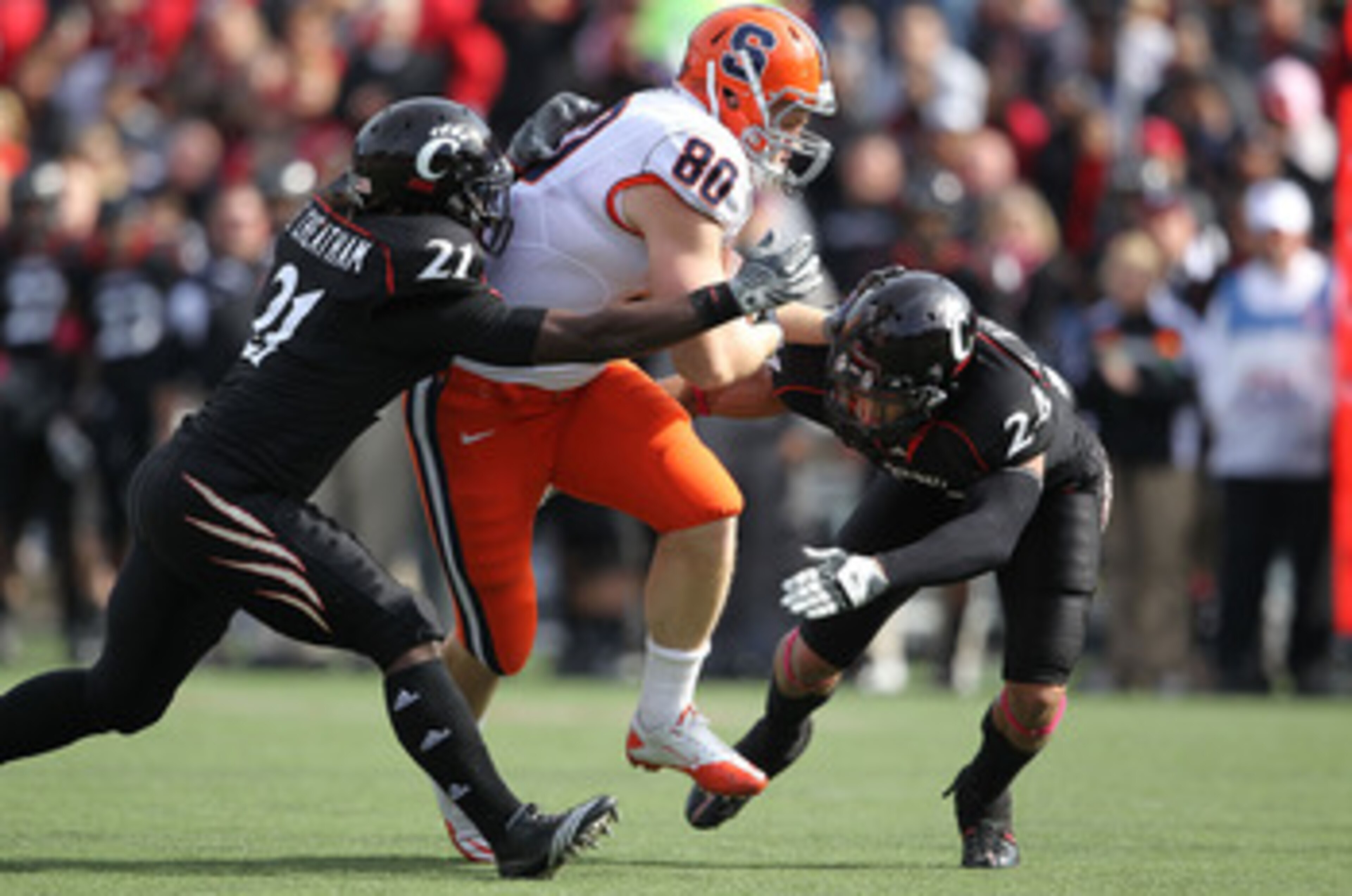 CINCINNATI - OCTOBER 30:  Nick Provo #80 of the Syracuse Orange runs with the ball while defended by Camerron Cheatham #21 and Wesley Richardson #24 of the Cincinnati Bearcats at Nippert Stadium on October 30, 2010 in Cincinnati, Ohio.  (Photo by Andy Lyo