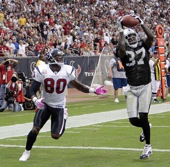 HOUSTON - OCTOBER 04:  Cornerback Chris Johnson #37 of the Oakland Raiders intercepts a pass intended for wide receiver Andre Johnson #80 of the Houston Texans in the first half at Reliant Stadium on October 4, 2009 in Houston, Texas.  (Photo by Bob Levey
