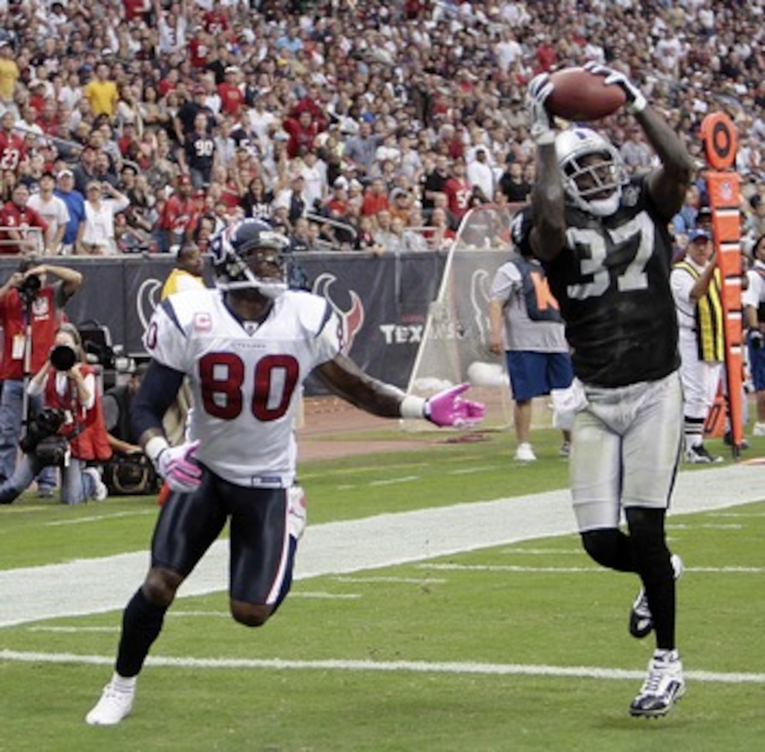 HOUSTON - OCTOBER 04:  Cornerback Chris Johnson #37 of the Oakland Raiders intercepts a pass intended for wide receiver Andre Johnson #80 of the Houston Texans in the first half at Reliant Stadium on October 4, 2009 in Houston, Texas.  (Photo by Bob Levey