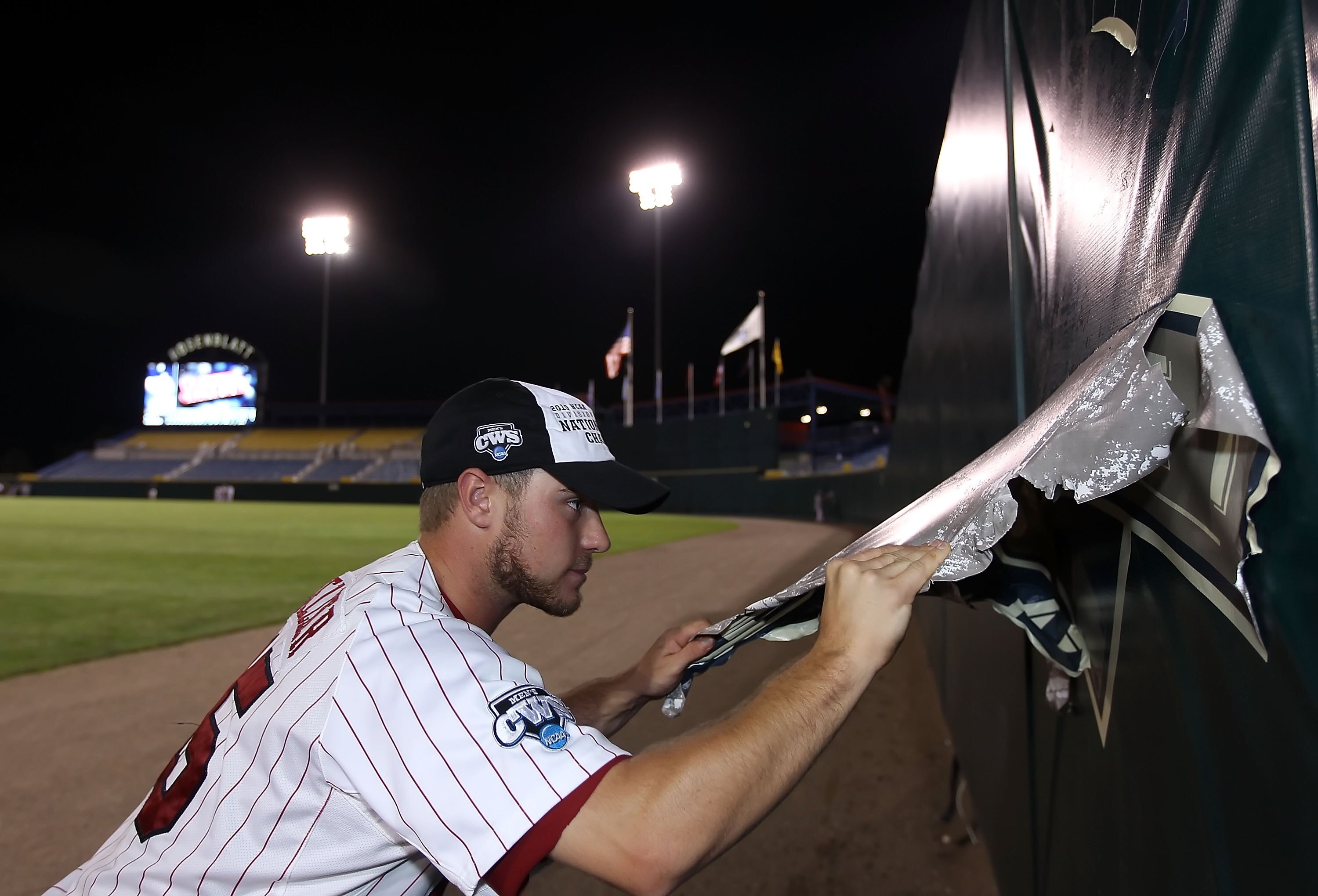 OMAHA, NE - JUNE 29:  Nolan Belcher #15 of the South Carolina Gamecocks tears down a logo from the outfield wall after defeating the UCLA Bruins in game 2 of the men's 2010 NCAA College Baseball World Series at Rosenblatt Stadium on June 29, 2010 in Omaha