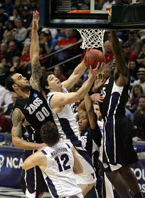 DENVER, CO - MARCH 19:  Jimmer Fredette #32 of the Brigham Young Cougars goes to the hoop against Robert Sacre #00 and Sam Dower #35 of the Gonzaga Bulldogs during the third round of the 2011 NCAA men's basketball tournament at Pepsi Center on March 19, 2