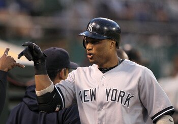 OAKLAND, CA - MAY 31:  Robinson Cano #24 of the New York Yankees is congratulated by teammates in the dugout after he hit a two run home run in the fifth inning against the Oakland Athletics at Oakland-Alameda County Coliseum on May 31, 2011 in Oakland, C