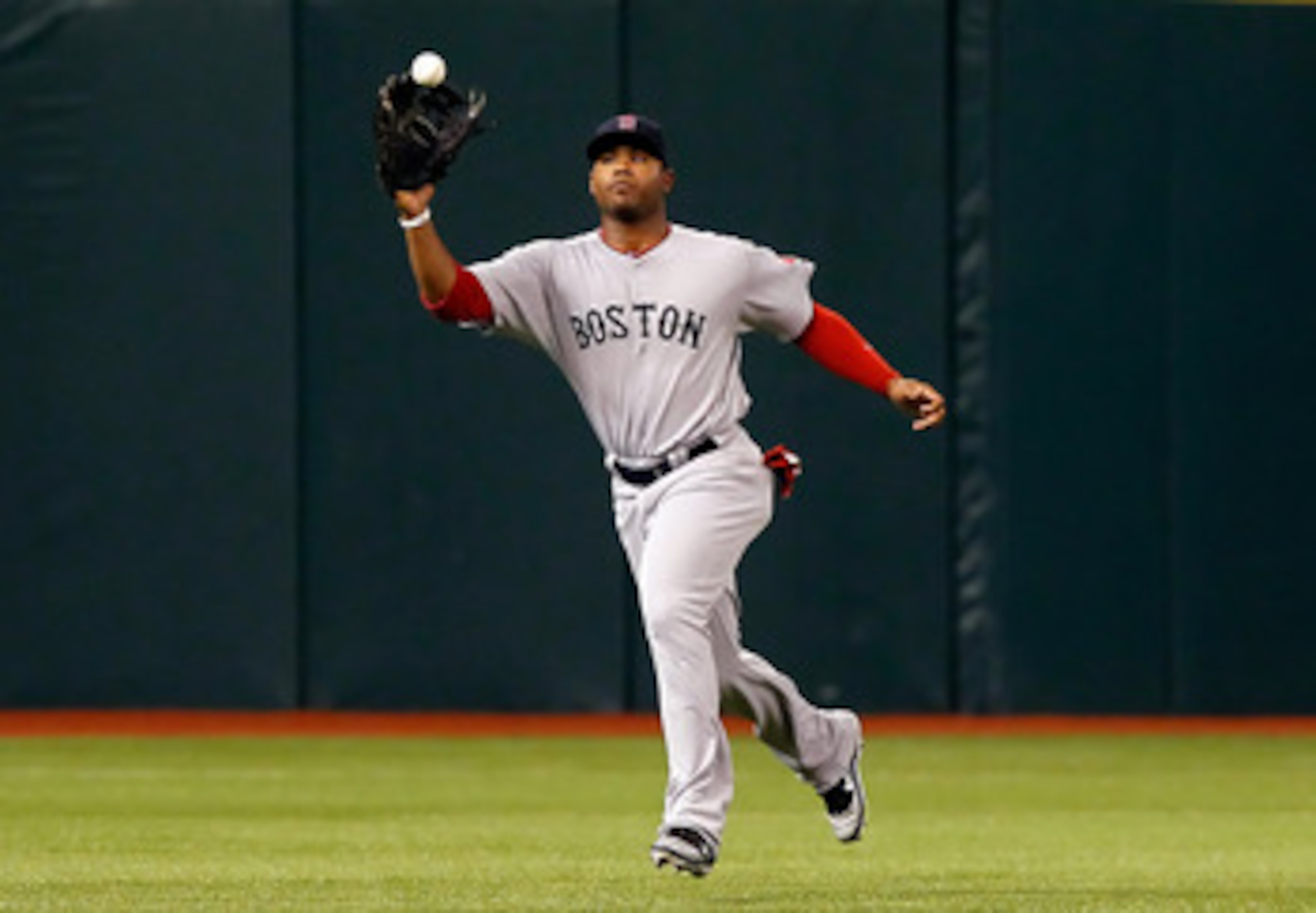 ST. PETERSBURG, FL - JUNE 14:  Outfielder Carl Crawford #13 of the Boston Red Sox catches a fly ball against the Tampa Bay Rays during the game at Tropicana Field on June 14, 2011 in St. Petersburg, Florida.  (Photo by J. Meric/Getty Images)