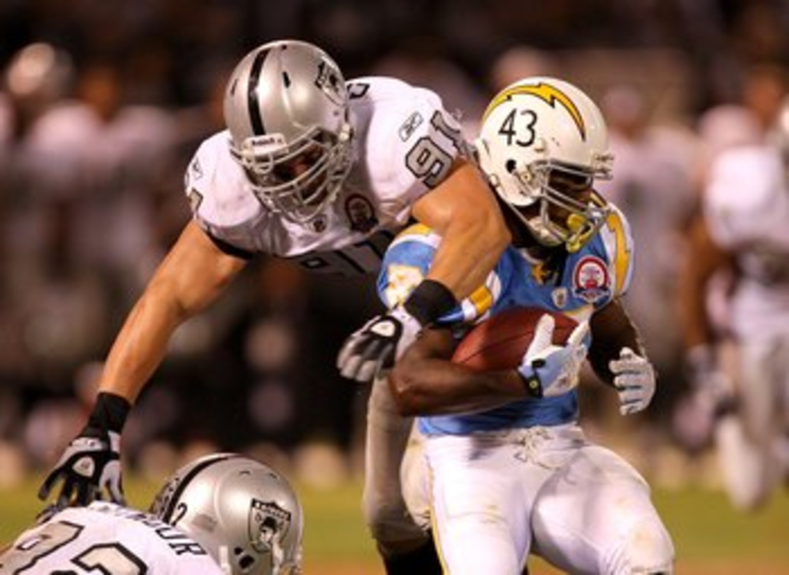 OAKLAND, CA - SEPTEMBER 14:  Darren Sproles #43 of the San Diego Chargers is hit by Trevor Scott #91 of the Oakland Raiders during their game on September 14, 2009 at the Oakland-Alameda County Coliseum in Oakland, California.  (Photo by Ezra Shaw/Getty I