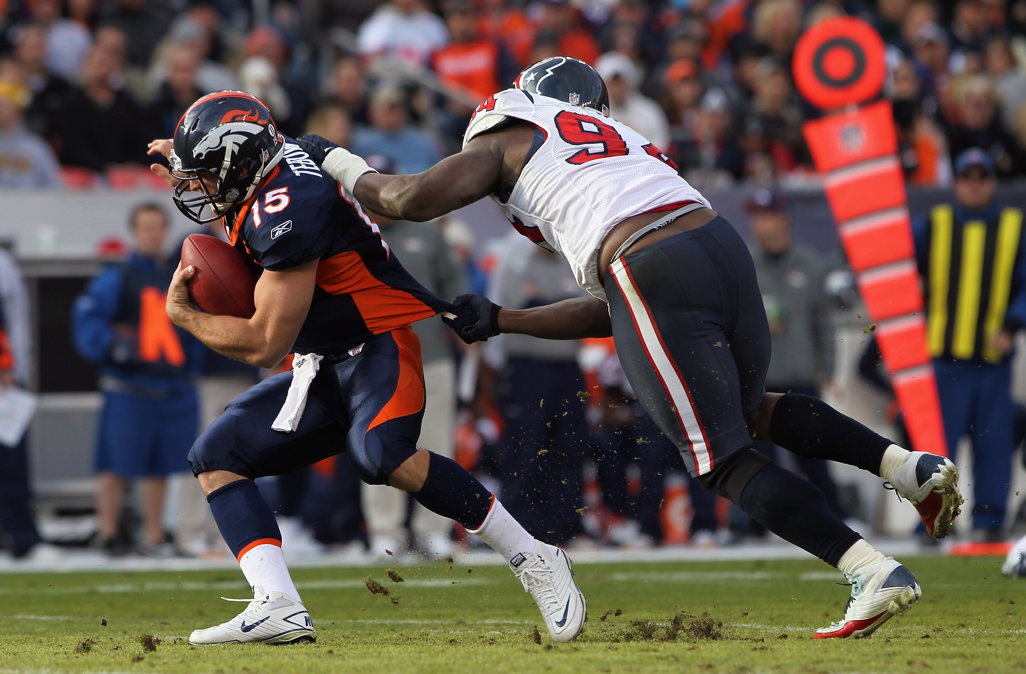 DENVER - DECEMBER 26:  Quarterback Tim Tebow #15 of the Denver Broncos eludes a sack attempt by defensive end Antonio Smith #94 of the Houston Texas at INVESCO Field at Mile High on December 26, 2010 in Denver, Colorado.  (Photo by Doug Pensinger/Getty Im