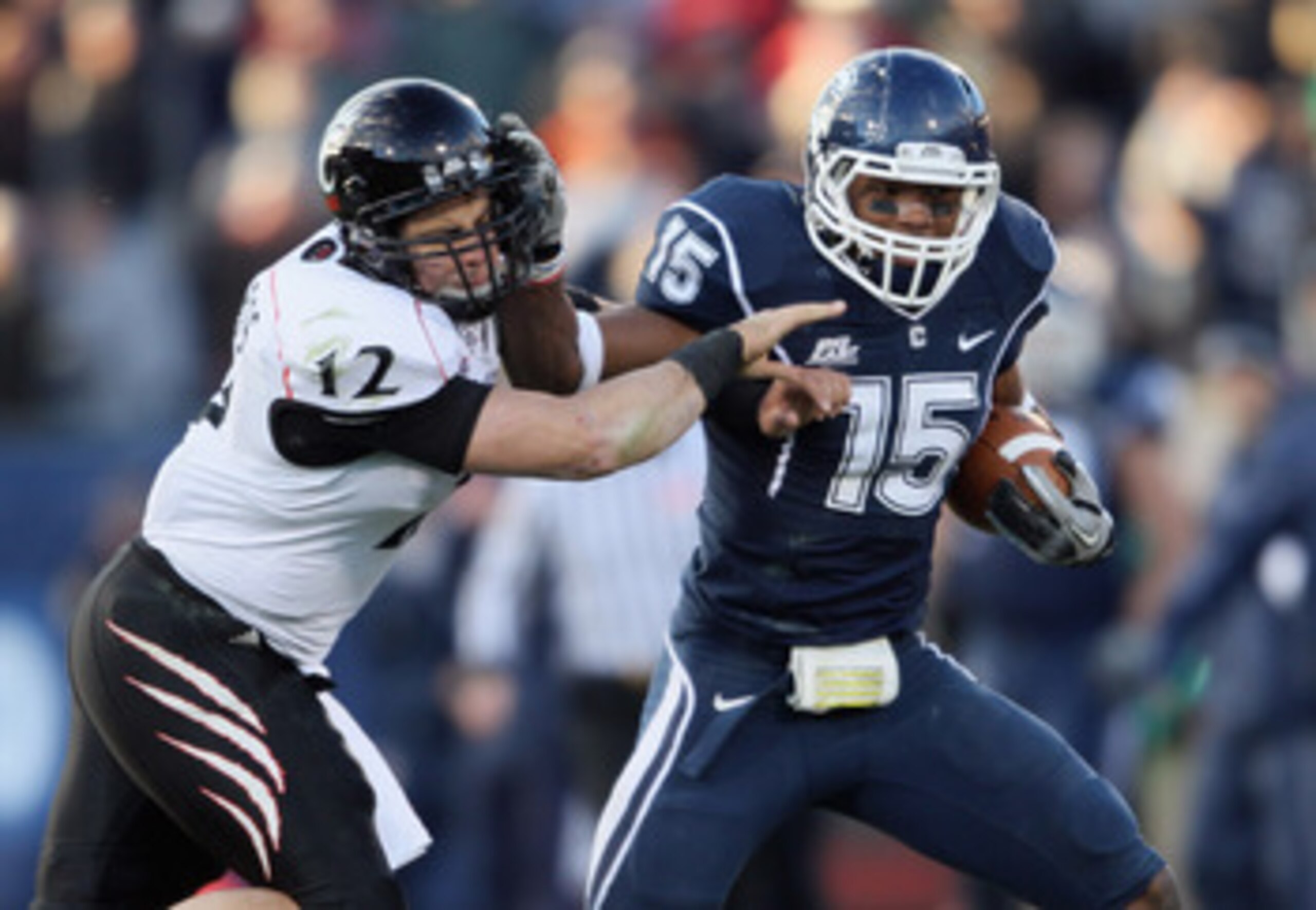 EAST HARTFORD, CT - NOVEMBER 27:  Jerome Junior #15 of the Connecticut Huskies is tackled by Zach Collaros #12 of the Cincinnati Bearcats after Junior intercepted Collaros' pass in the fourth quarter on November 27, 2010 at Rentschler Field in East Hartfo