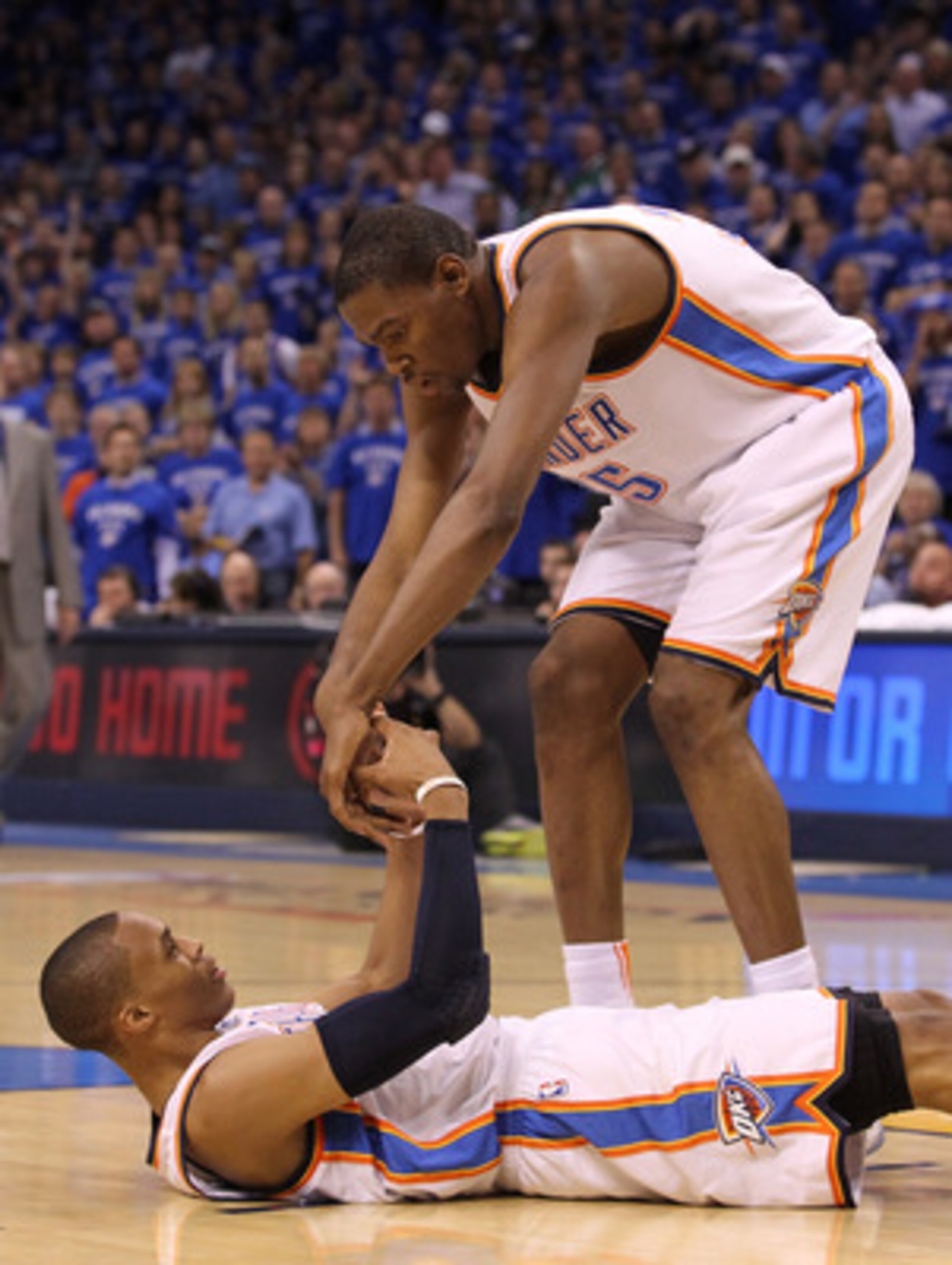 OKLAHOMA CITY, OK - MAY 23:  Kevin Durant #35 helps up teammate Russell Westbrook #0 of the Oklahoma City Thunder in the first half while taking on the Dallas Mavericks in Game Four of the Western Conference Finals during the 2011 NBA Playoffs at Oklahoma
