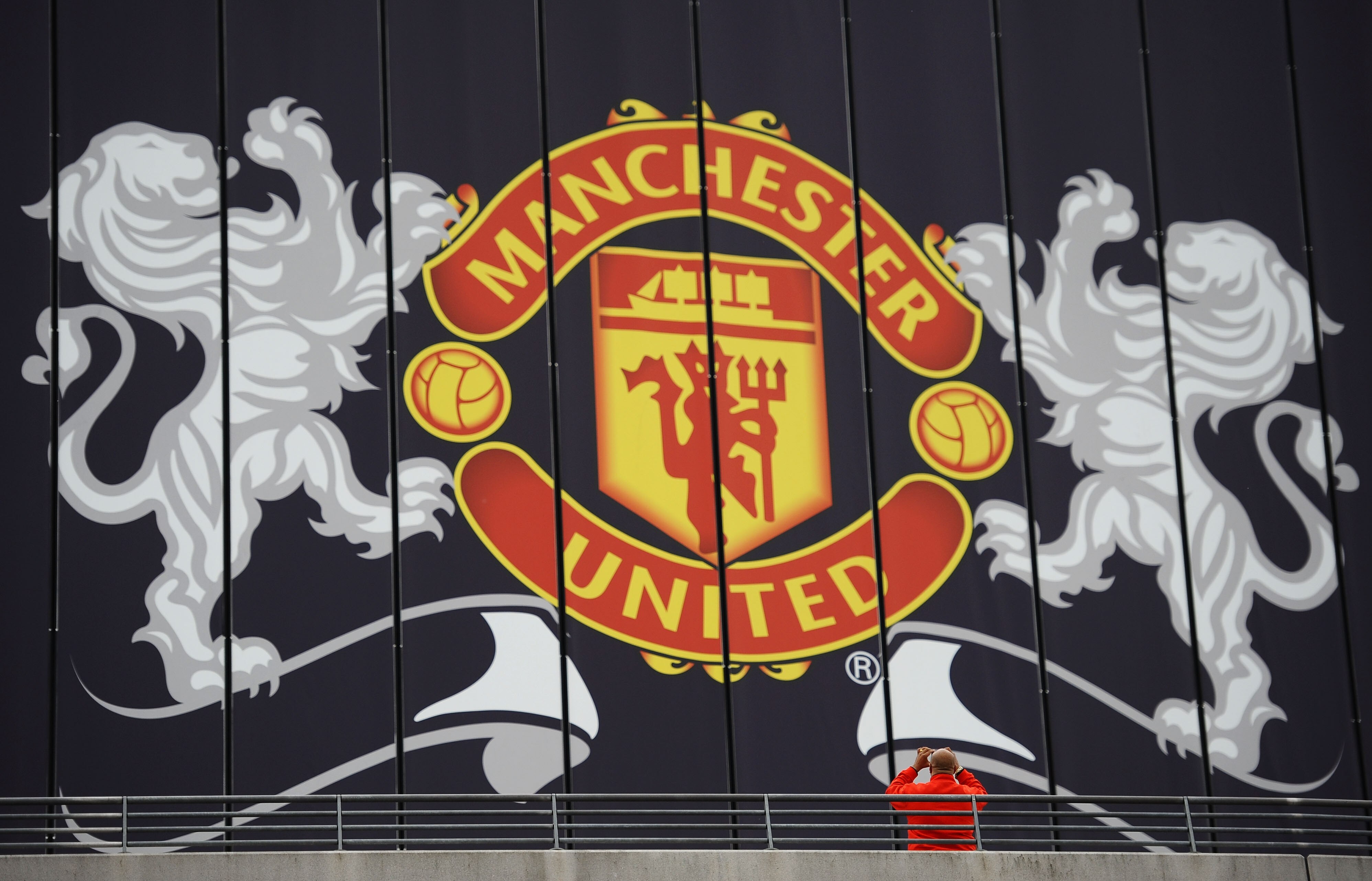 LONDON, ENGLAND - MAY 28:  A fan photographs a Manchester United billboard ahead of the UEFA Champions League final between FC Barcelona and Manchester United FC at Wembley Stadium on May 28, 2011 in London, England.  (Photo by Laurence Griffiths/Getty Im