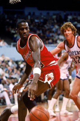 LOS ANGELES, CA - DECEMBER 1984:  Michael Jordan #23 of the Chicago Bulls moves the ball against Bill Walton #32 of the Los Angeles Clippers during a December 1984 season game at the Sports Arena in Los Angeles, California.  (Photo by Rick Stewart/Getty I