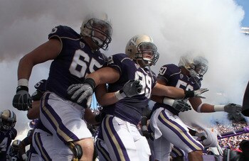 SEATTLE - SEPTEMBER 18:  Ryan Tolar #65, Cameron Elisara #99, and Kalani Aldrich #50 of the Washington Huskies run out of the tunnel prior to the game against the Nebraska Cornhuskers on September 18, 2010 at Husky Stadium in Seattle, Washington. The Corn