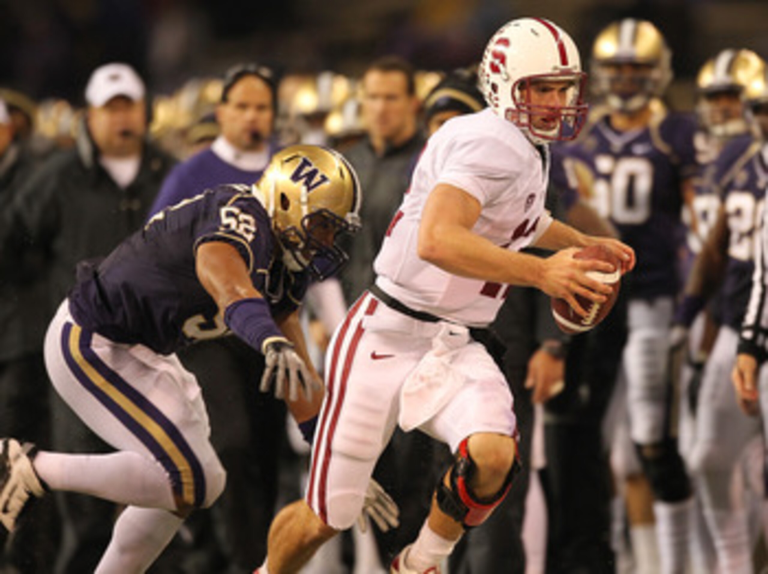 SEATTLE - OCTOBER 30:  Quarterback Andrew Luck #12 of the Stanford Cardinal rushes against Hau'oli Jamora #52 of the Washington Huskies on October 30, 2010 at Husky Stadium in Seattle, Washington. Stanford defeated Washington 41-0. (Photo by Otto Greule J