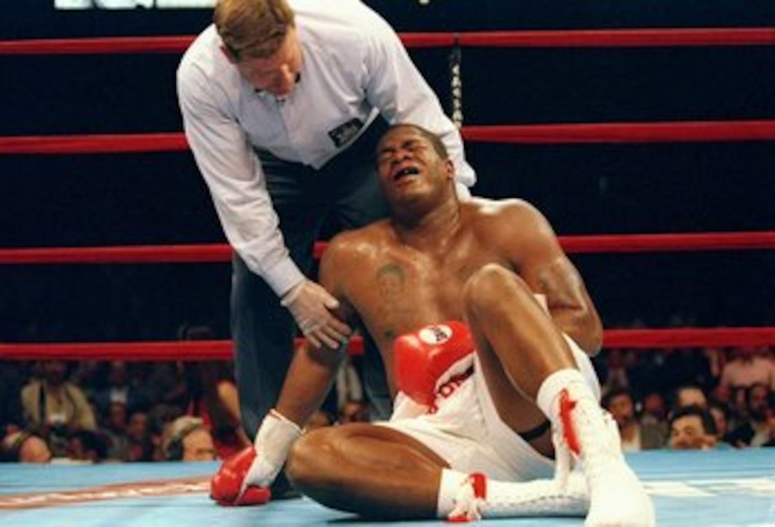 11 Jul 1996: Riddick Bowe is on the canvas and being attended to by referee Wayne Kelly after being stopped with a low blow by Andrew Golota that ended their fight in the 7th round at Madison Square Garden in New York City. Bowe was awarded a technical de