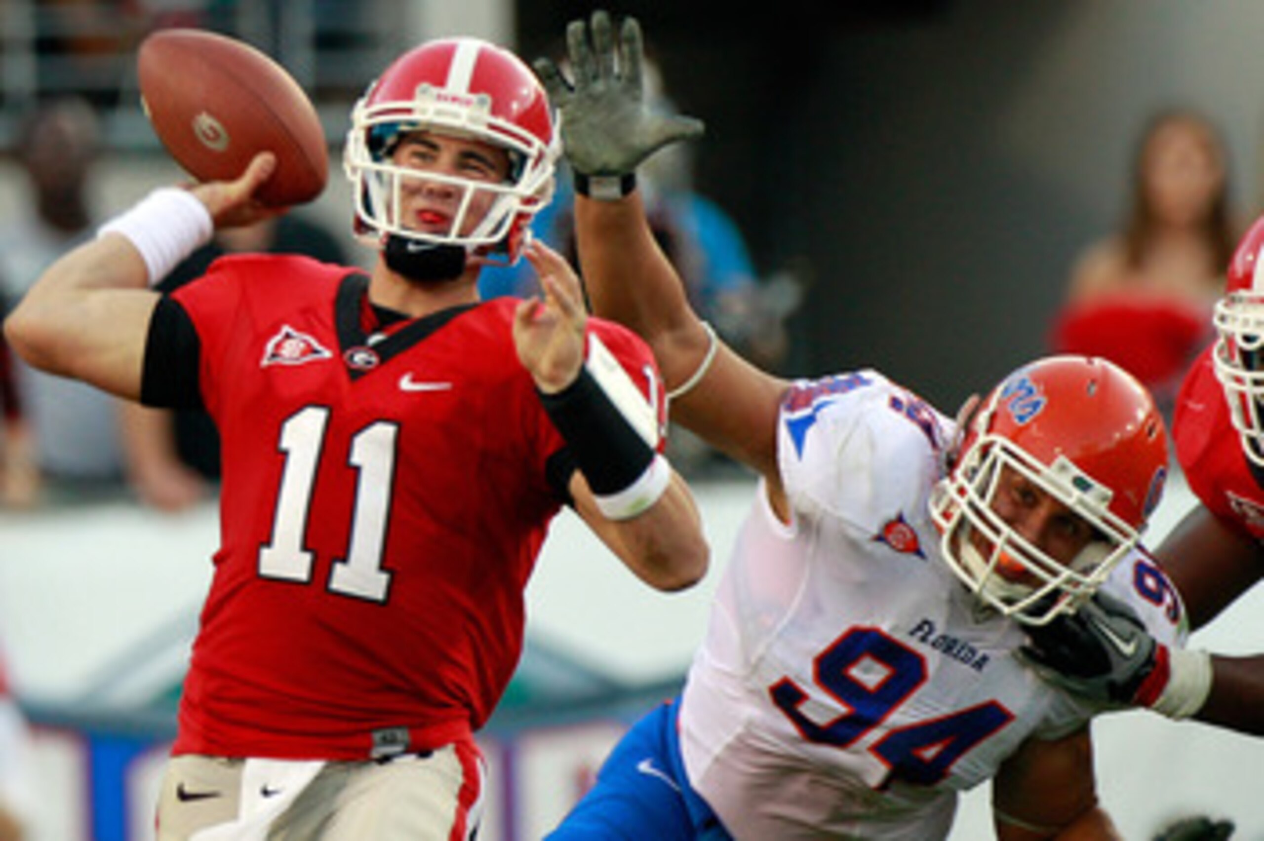 JACKSONVILLE, FL - OCTOBER 30:  Quarterback Aaron Murray #11 of the Georgia Bulldogs attempts a pass while being pressured by Justin Trattou #94 of the Florida Gators during the game at EverBank Field on October 30, 2010 in Jacksonville, Florida.  (Photo