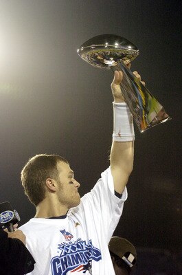 Tom Brady holds the Vince Lombardi Trophy as he stands on the podium after The New England Patriots defeated The Philadelphia Eagles in Super Bowl XXXIX at Alltel Staduim in Jacksonville, Florida.  (Photo by Al Messerschmidt/Getty Images)