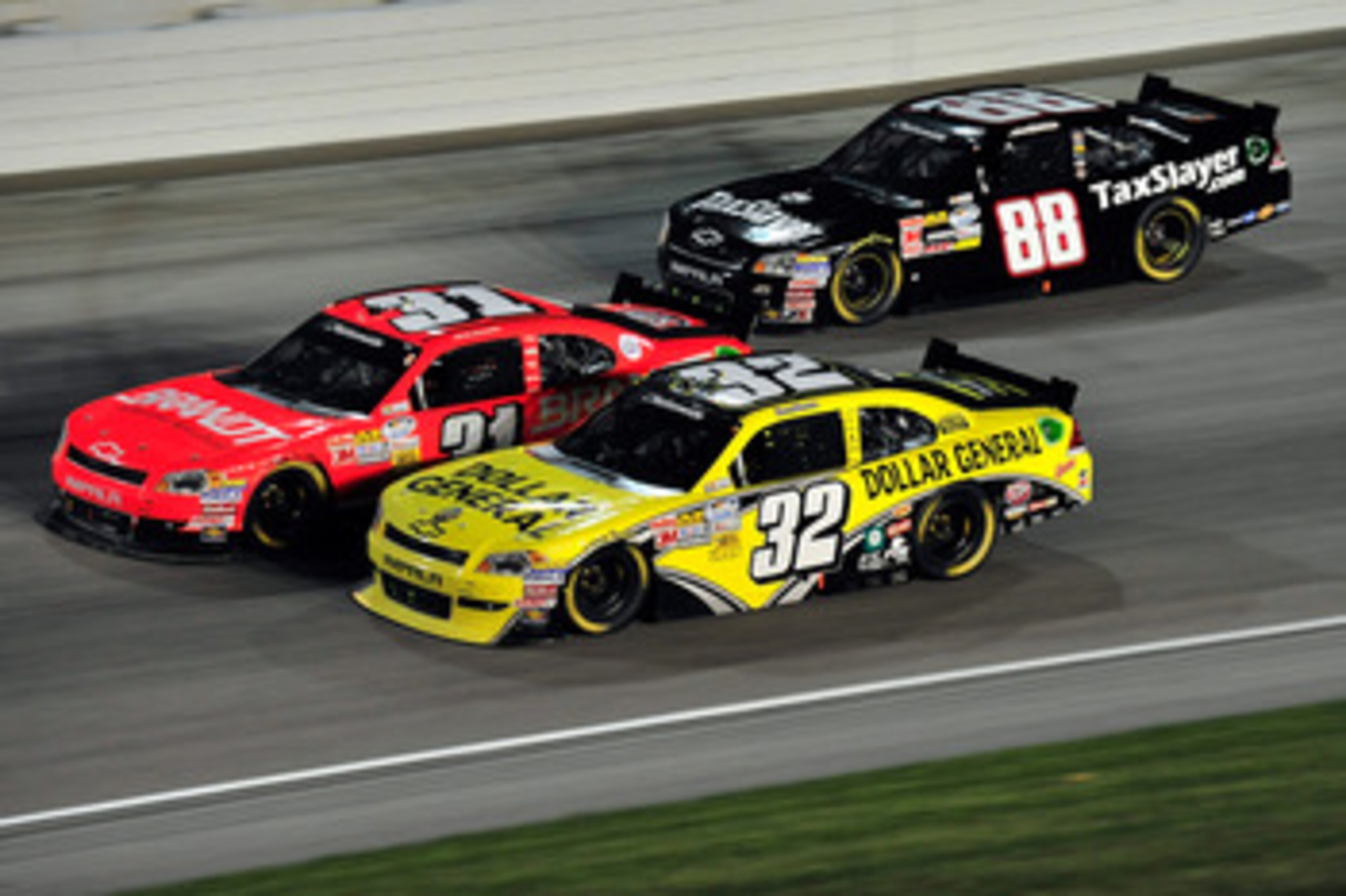 JOLIET, IL - JUNE 4: Reed Sorenson, driver of the #32 Dollar General Toyota, races Justin Allgaier, driver of the #31 Brandt Chevrolet, and Aric Almirola, driver of the #88 TaxSlayer.com Chevrolet, during the NASCAR Nationwide Series STP 300 at Chicagolan
