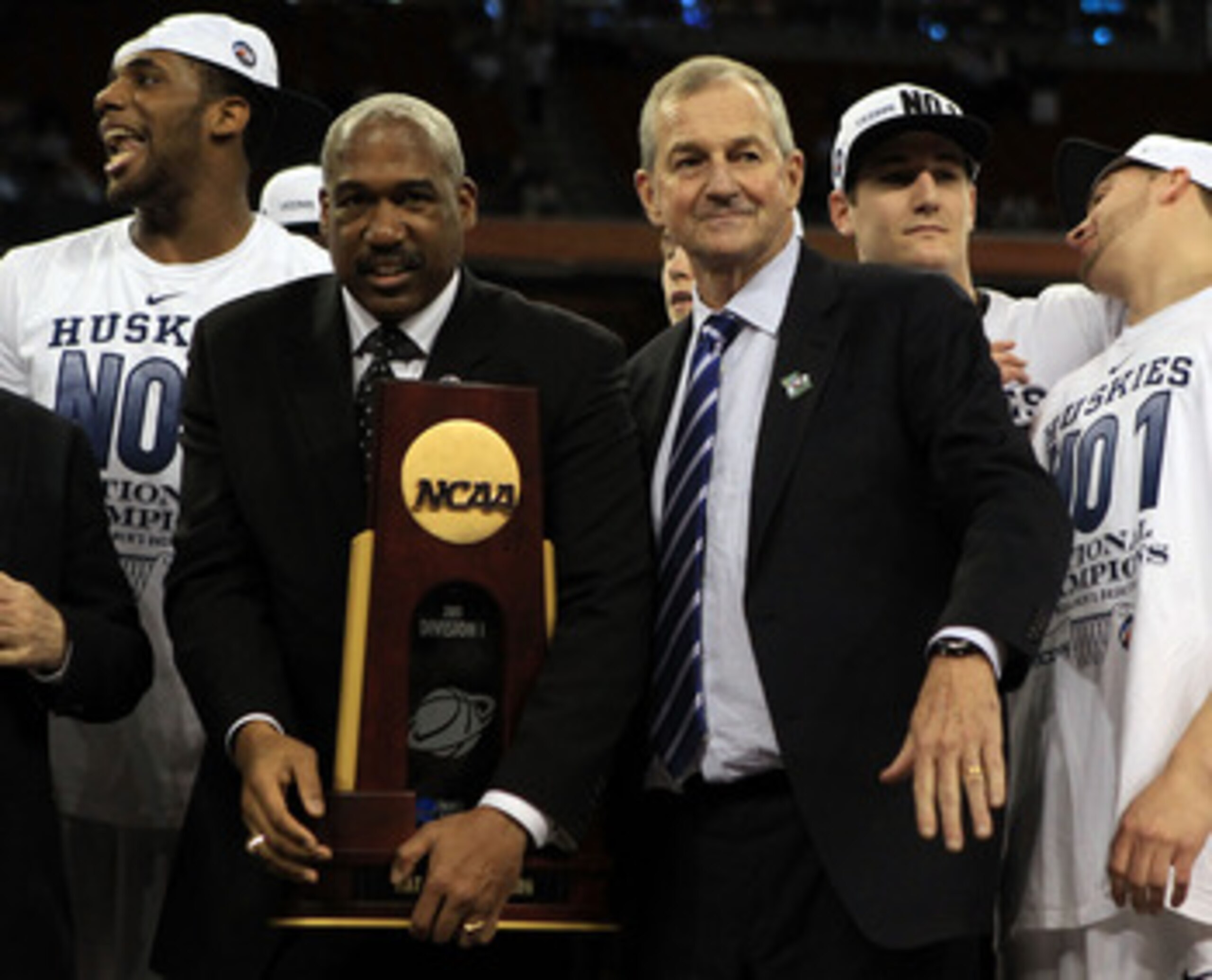 HOUSTON, TX - APRIL 04:  Athletic director Gene Smith of the Ohio State Buckeyes stands with head coach Jim Calhoun of the Connecticut Huskies as the Huskies celebrate with his team and the trophy after defeating the Butler Bulldogs to win the National Ch