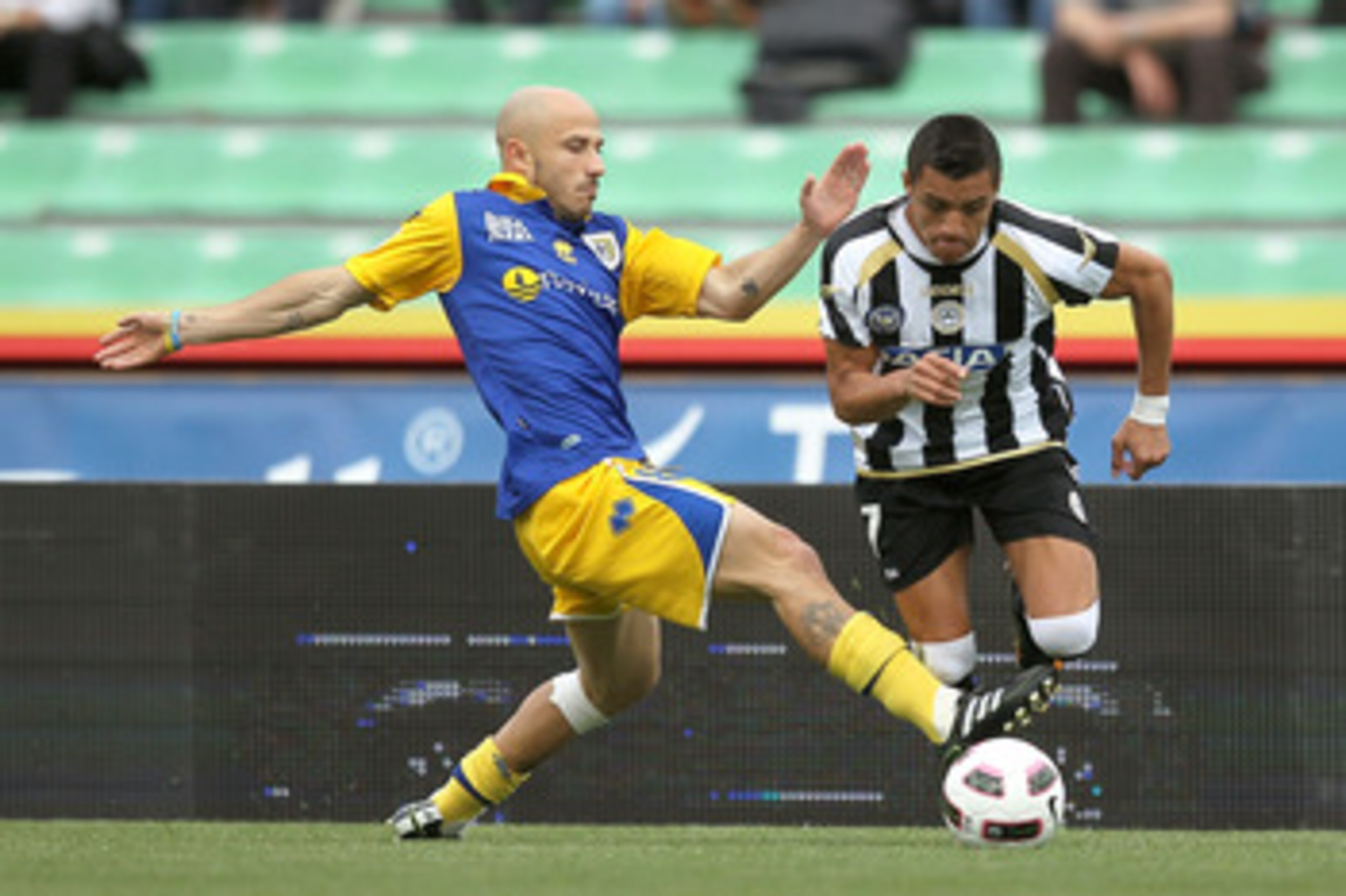 UDINE, ITALY - APRIL 23: Alexis Sanchez of Udinese Calcio fights for the ball with Francesco Valiani of Parma FC during the Serie A match between Udinese Calcio and Parma FC at Stadio Friuli on April 23, 2011 in Udine, Italy.  (Photo by Gabriele Maltinti/