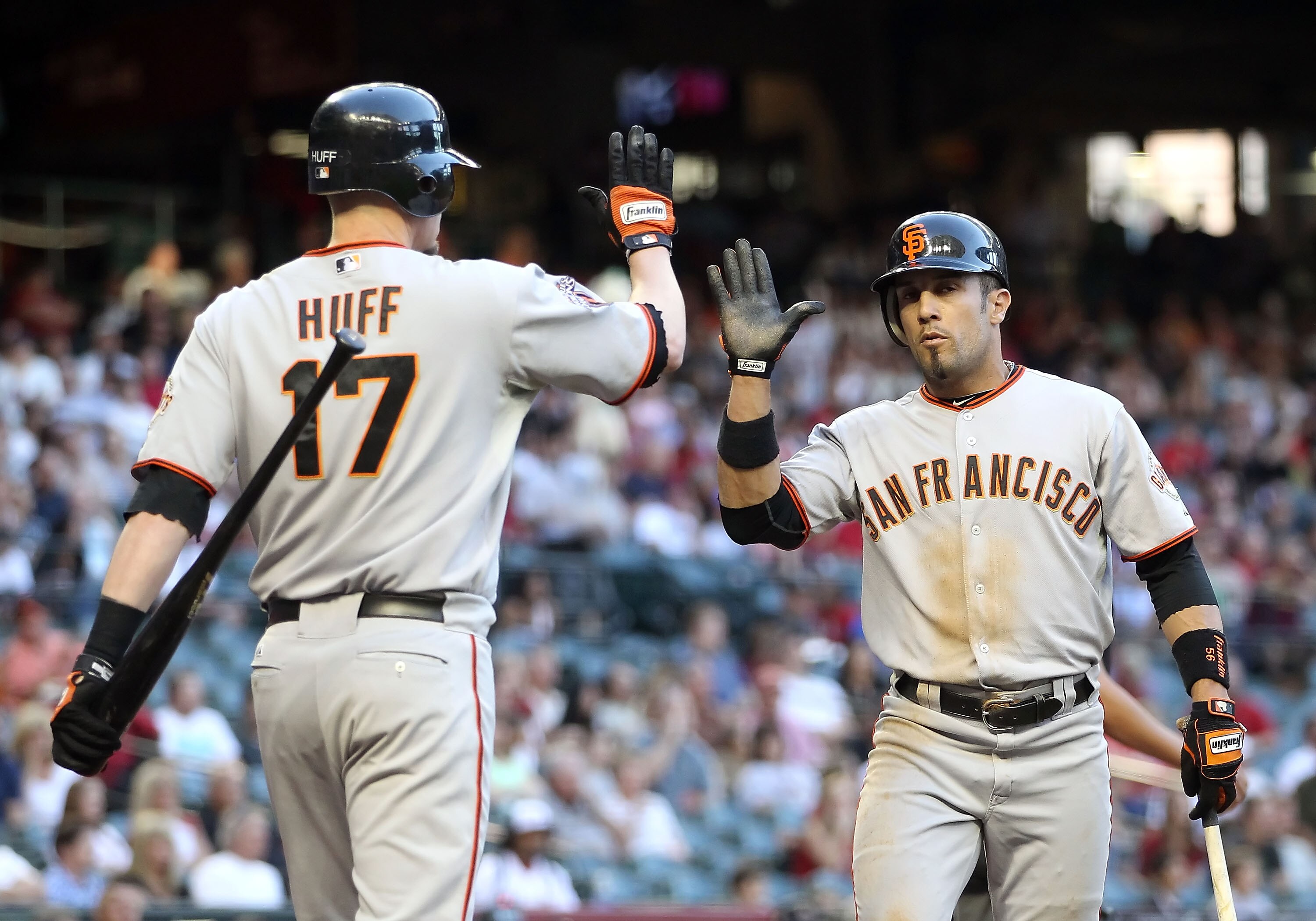 PHOENIX, AZ - JUNE 14:  Andres Torres #56 of the San Francisco Giants high fives teammate Aubrey Huff #17 after scoring against the Arizona Diamondbacks during the first inning of the Major League Baseball game at Chase Field on June 14, 2011 in Phoenix,