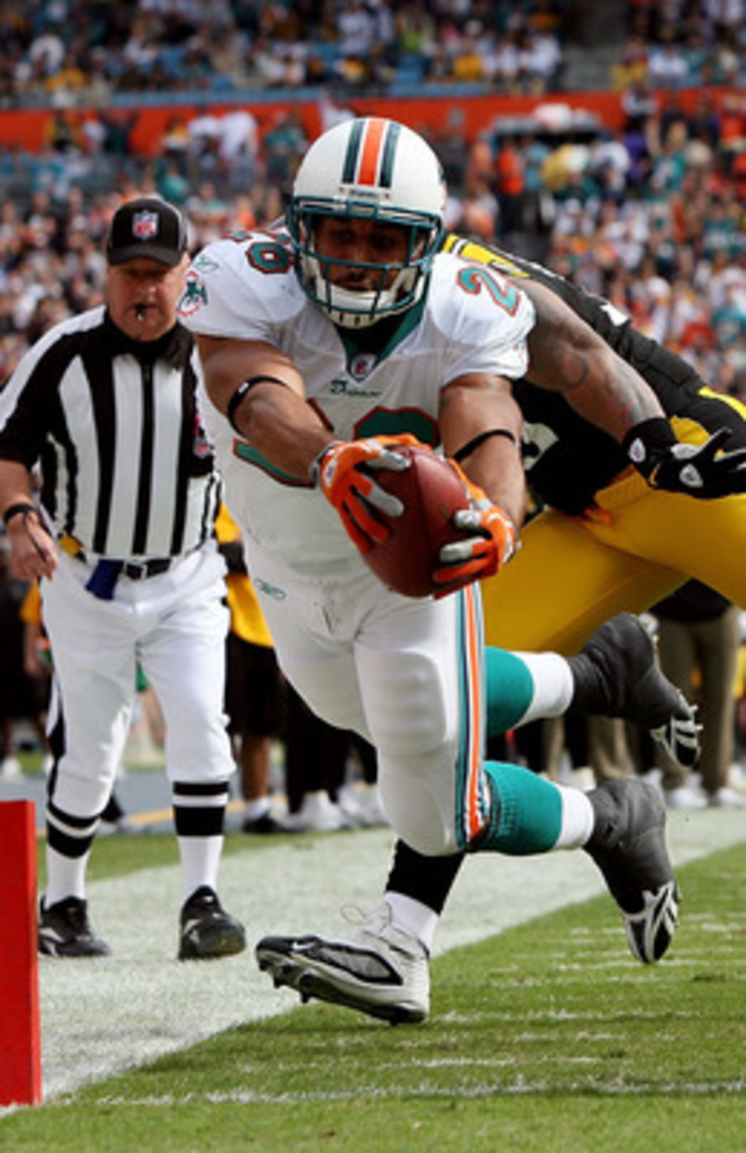 MIAMI - JANUARY 03:  Running back Lex Hilliard #26 of the Miami Dolphins dives for a touchdown past linebacker LaMarr Woodley #56 and Deshea Townsend #26 of the Pittsburgh Steelers at Land Shark Stadium on January 3, 2010 in Miami, Florida.  (Photo by Dou