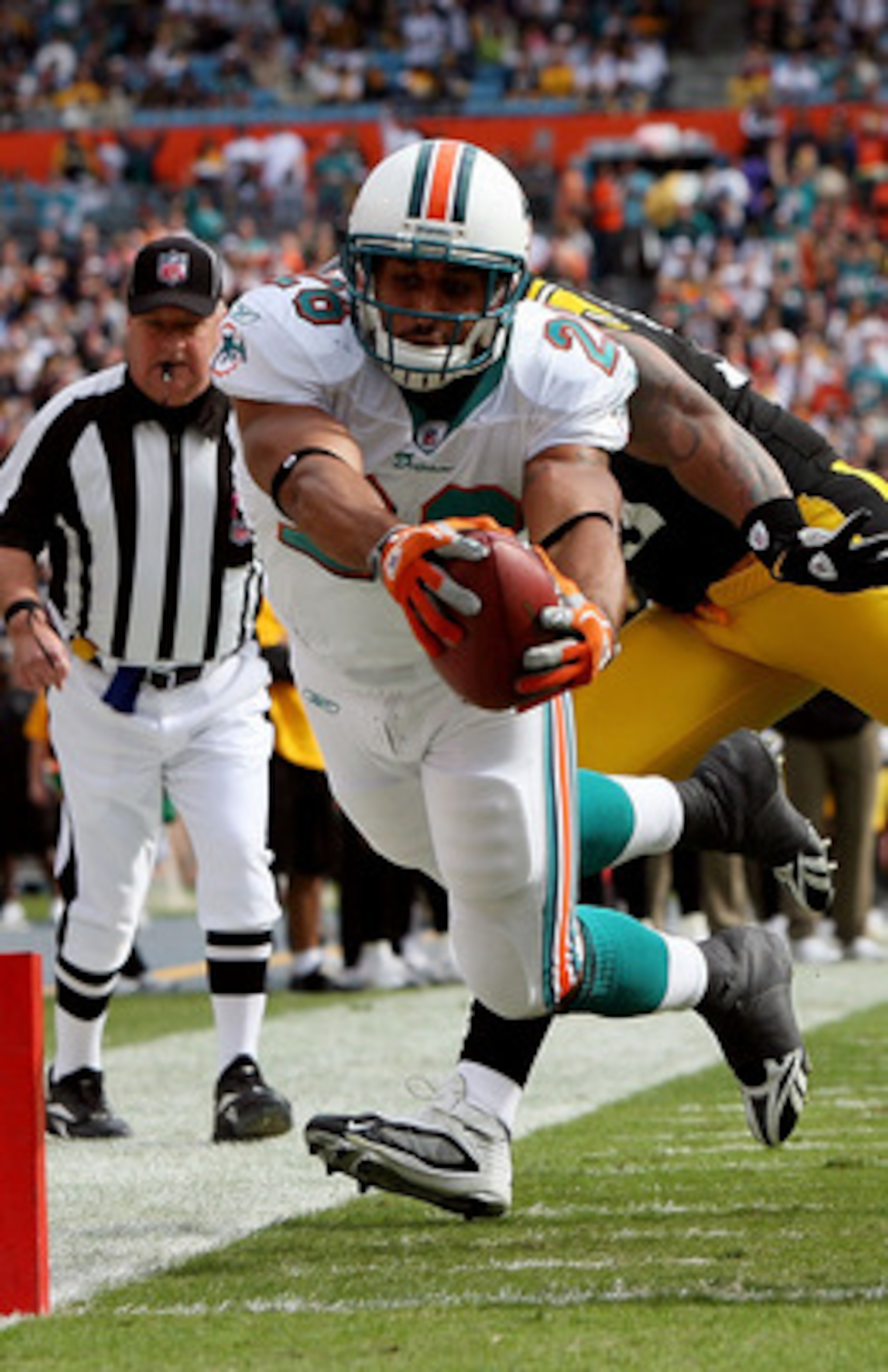MIAMI - JANUARY 03:  Running back Lex Hilliard #26 of the Miami Dolphins dives for a touchdown past linebacker LaMarr Woodley #56 and Deshea Townsend #26 of the Pittsburgh Steelers at Land Shark Stadium on January 3, 2010 in Miami, Florida.  (Photo by Dou