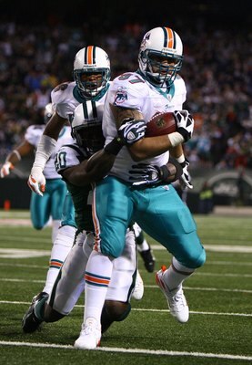 EAST RUTHERFORD, NJ - DECEMBER 28:  Phillip Merling #97 of The Miami Dolphins rumbles in for a touchdown after making an interception thrown by Brett Favre of The New York Jets during their game on December 28, 2008 at Giants Stadium in East Rutherford, N