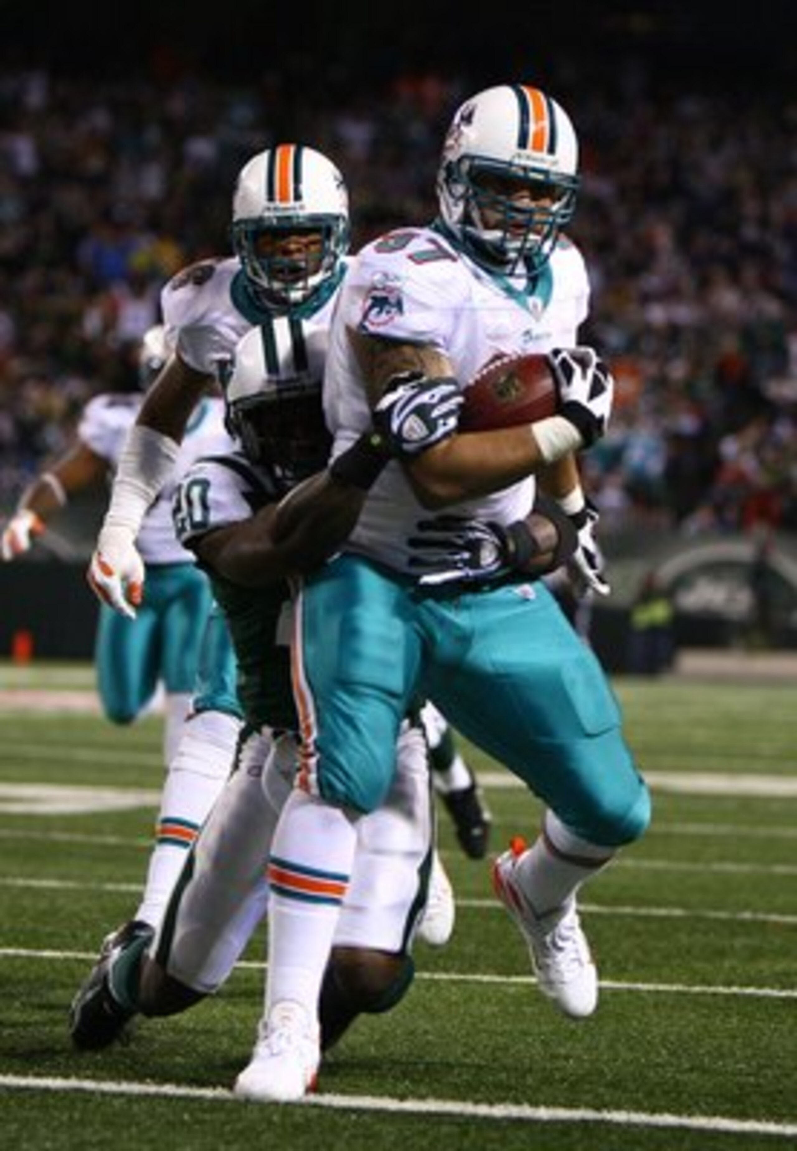 EAST RUTHERFORD, NJ - DECEMBER 28:  Phillip Merling #97 of The Miami Dolphins rumbles in for a touchdown after making an interception thrown by Brett Favre of The New York Jets during their game on December 28, 2008 at Giants Stadium in East Rutherford, N