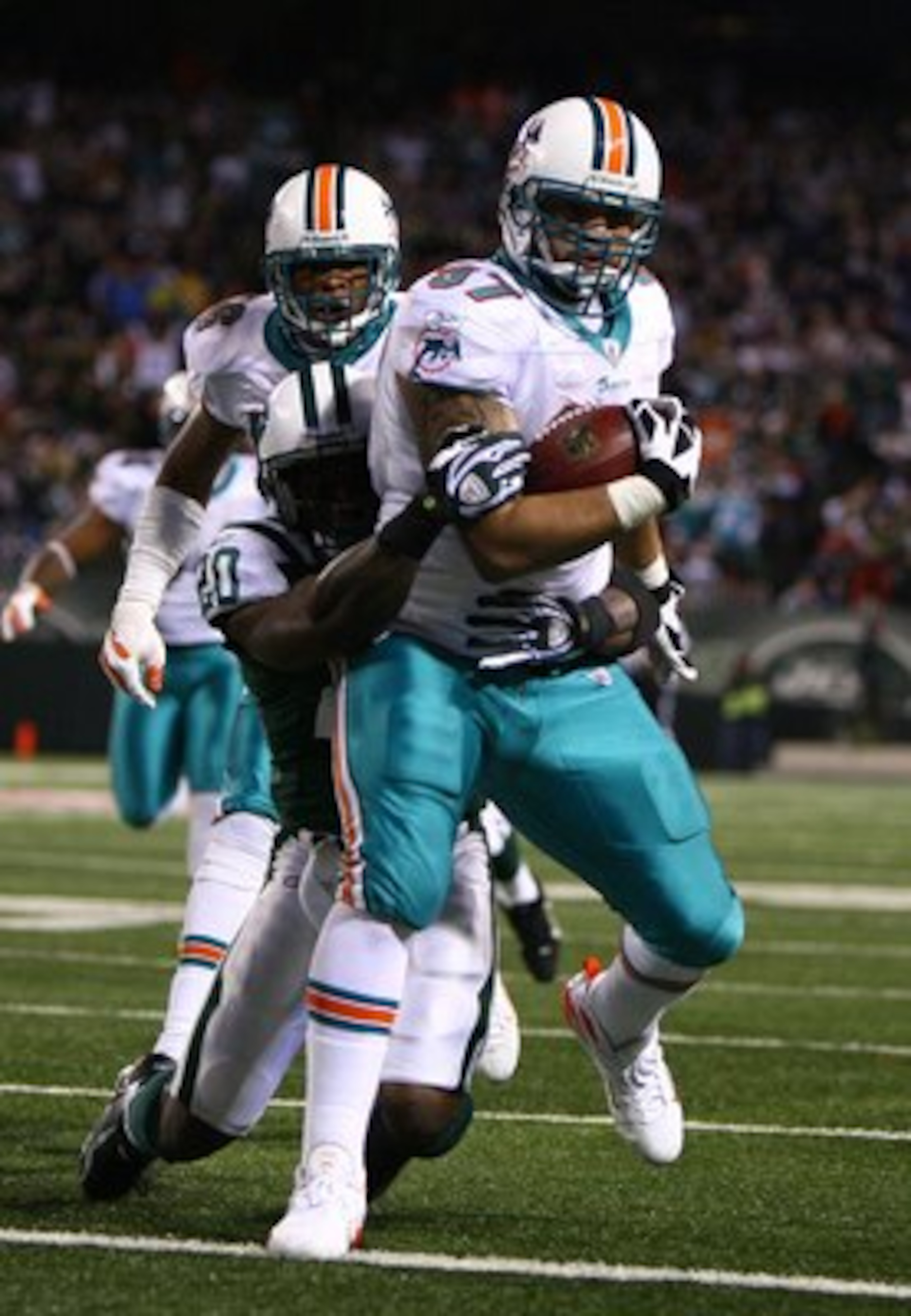EAST RUTHERFORD, NJ - DECEMBER 28:  Phillip Merling #97 of The Miami Dolphins rumbles in for a touchdown after making an interception thrown by Brett Favre of The New York Jets during their game on December 28, 2008 at Giants Stadium in East Rutherford, N