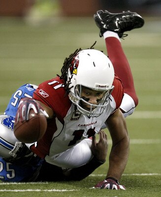 DETROIT, MI - DECEMBER 20: Larry Fitzgerald #11 of the  Arizona Cardinals reaches for a first down while being tackled by Marvin White #25 of the Detroit Lions on December 20, 2009 at Ford Field in Detroit, Michigan.  (Photo by Gregory Shamus/Getty Images
