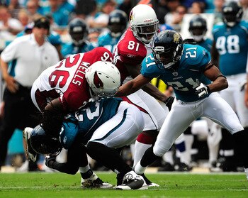 JACKSONVILLE, FL - SEPTEMBER 20:  Beanie Wells #26 is tackked by Reggie Nelson #25 of the Jacksonville Jaguars during the game at Jacksonville Municipal Stadium on September 20, 2009 in Jacksonville, Florida.  (Photo by Sam Greenwood/Getty Images)